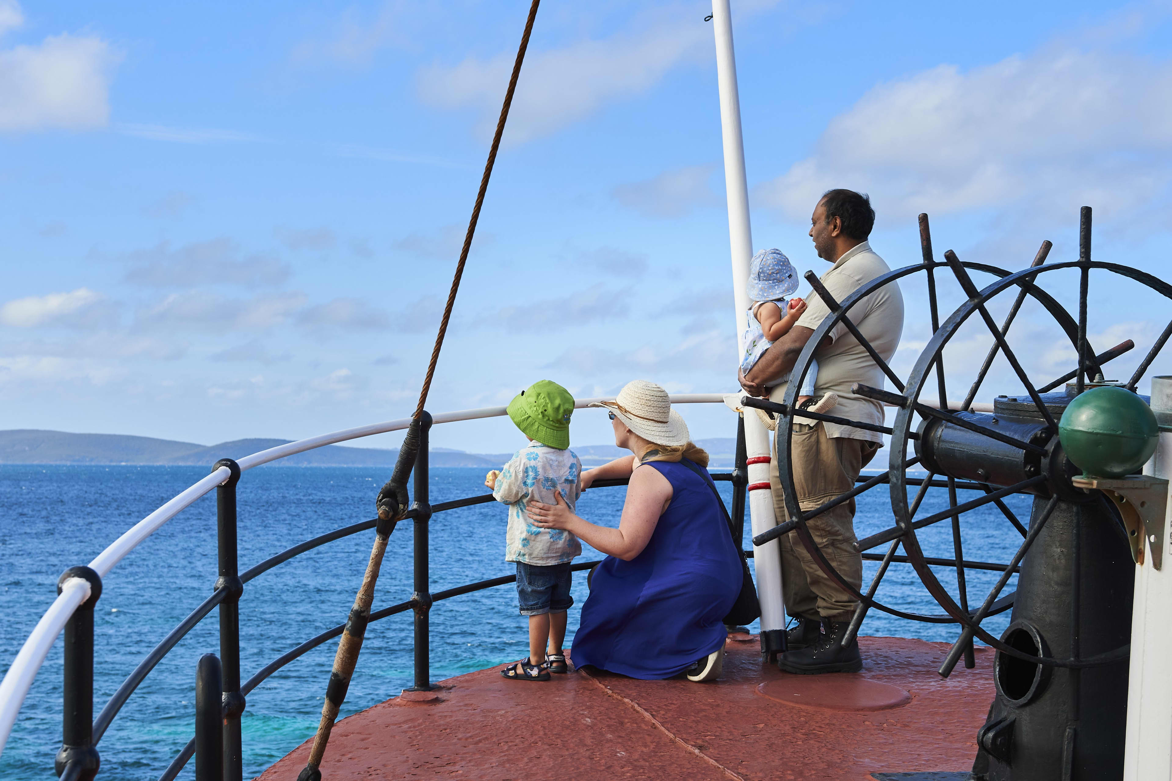 Family onboard whaling ship overlooking deck into water