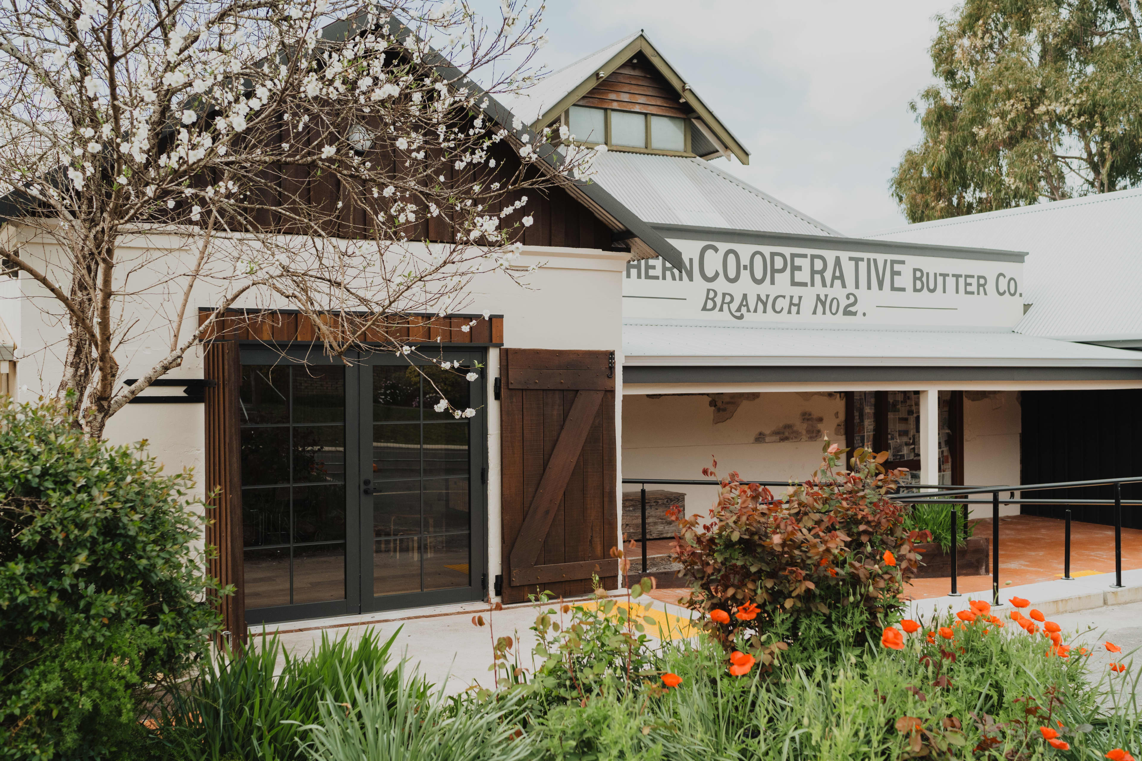 Outside building with original butter factory sign and garden in foreground