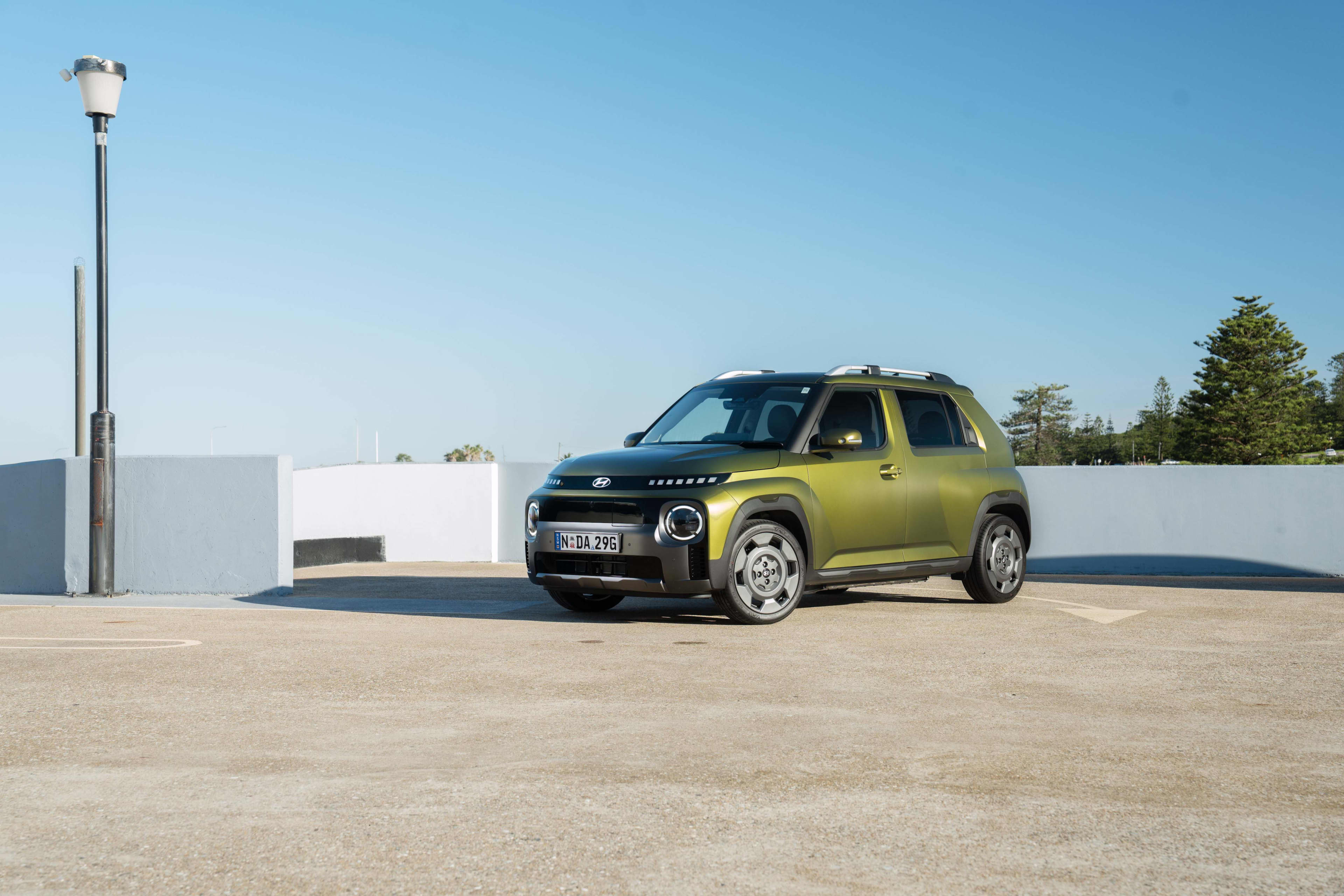 A green Hyundai_Inster in a car park