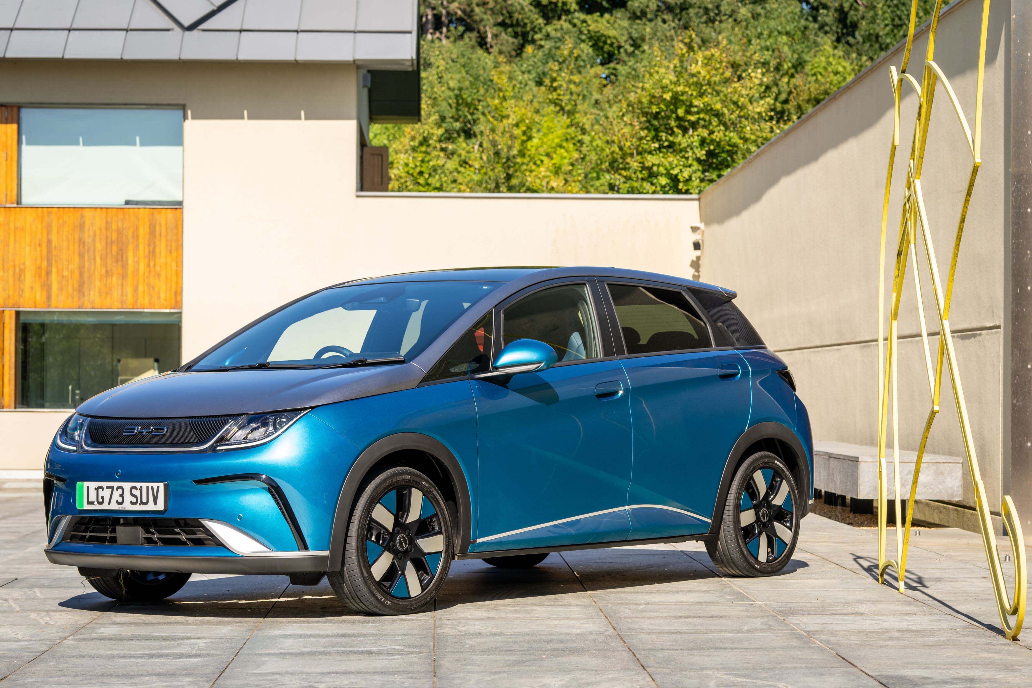 A blue BYD_Dolphin in a suburban driveway