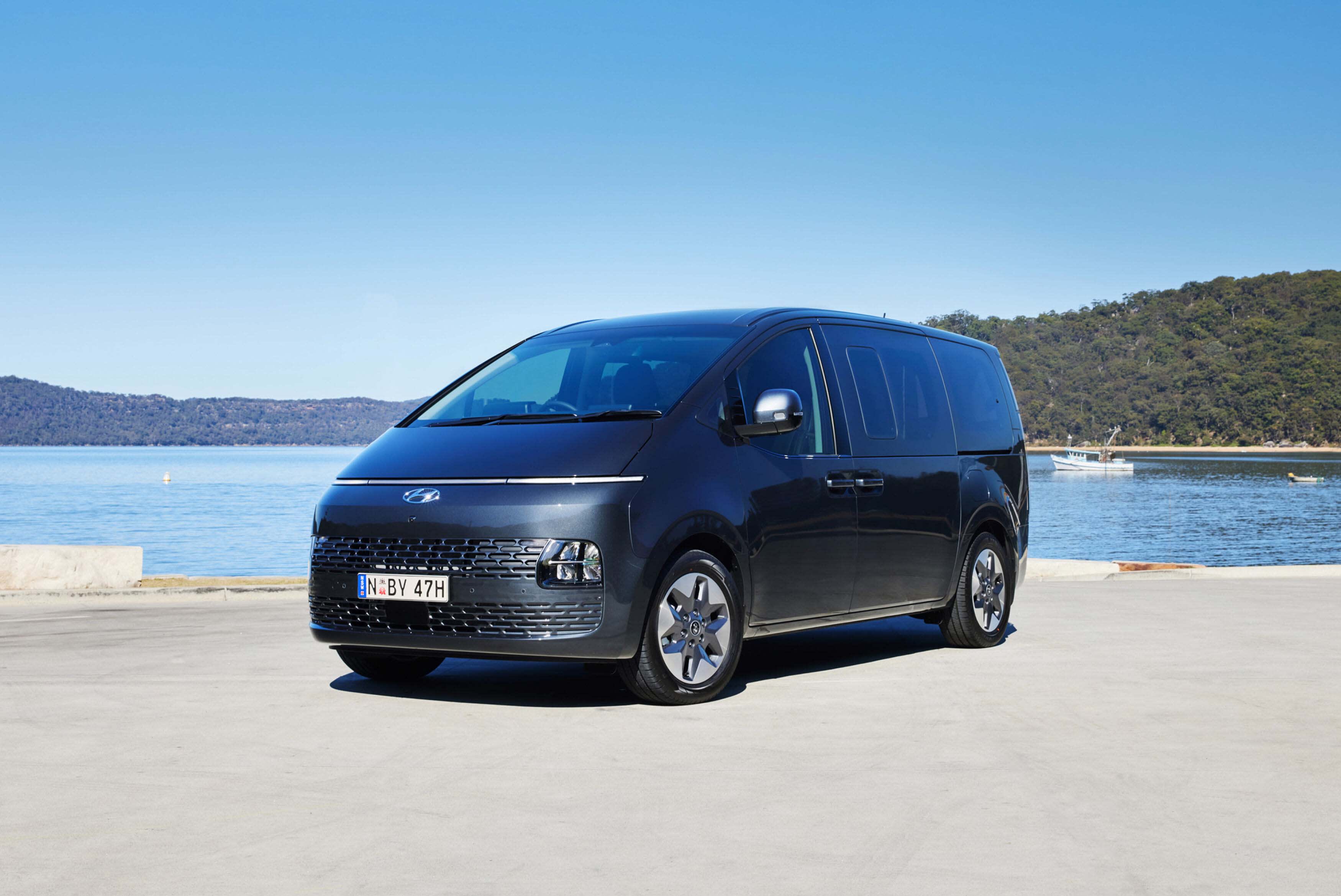 A black  Hyundai_STARIA parked near a lake
