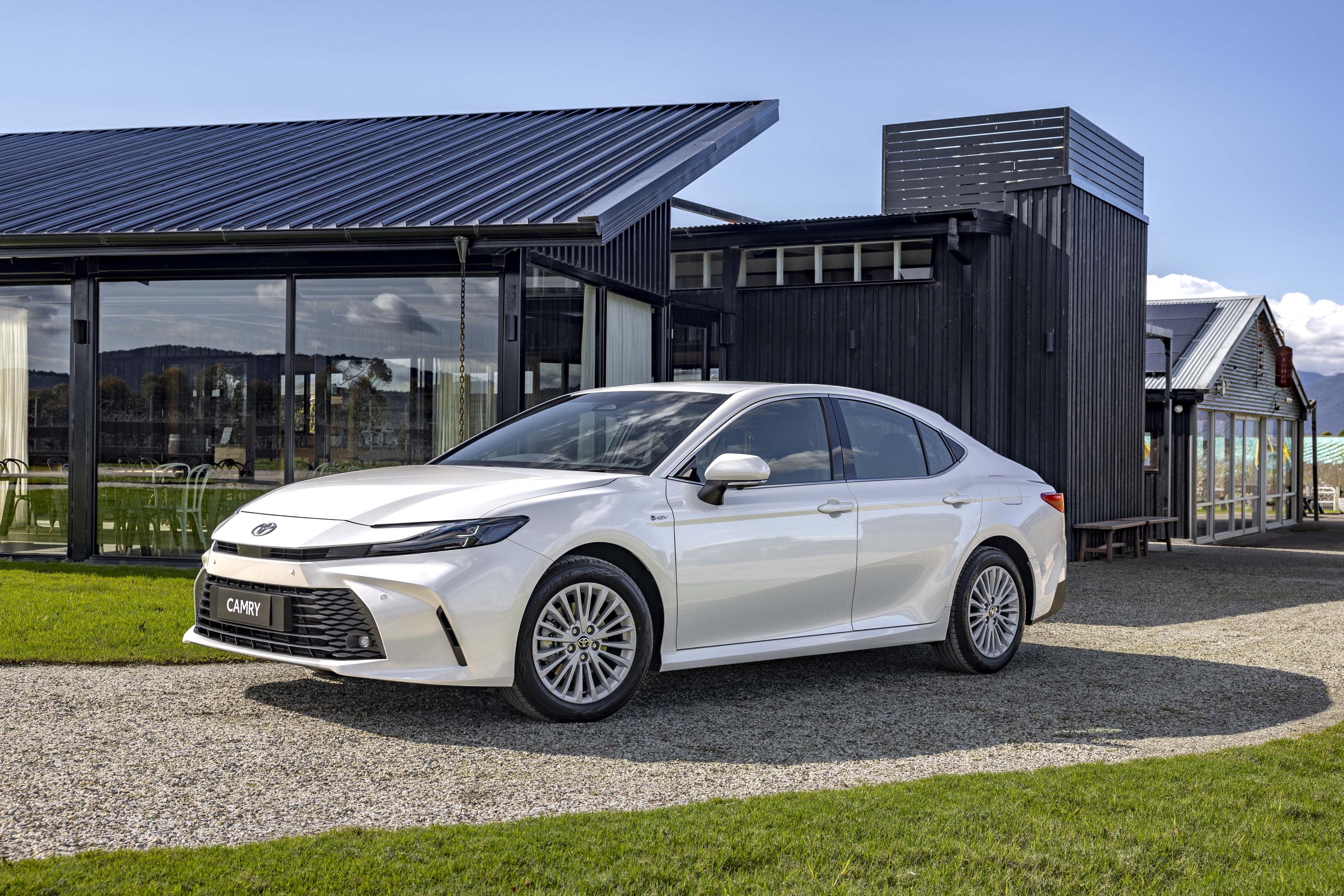 A white Toyota_Camry parked outside a home