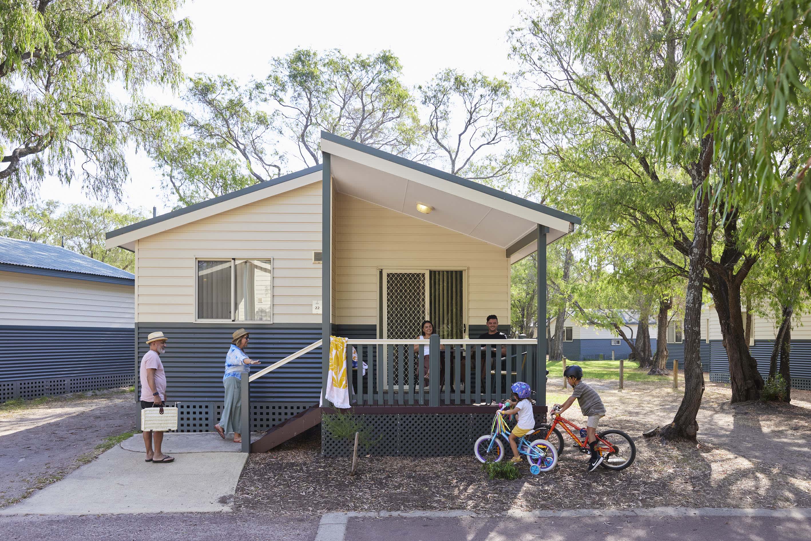 A family outside a resort cabin