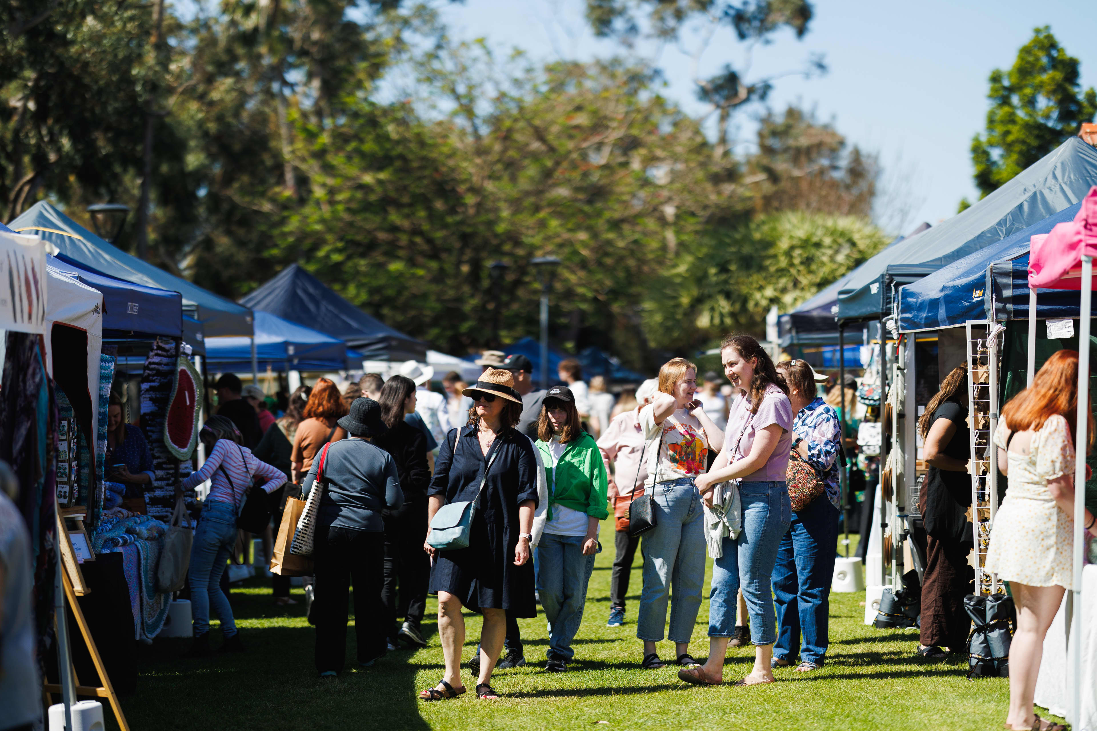 Group of people browsing market stalls outdoors