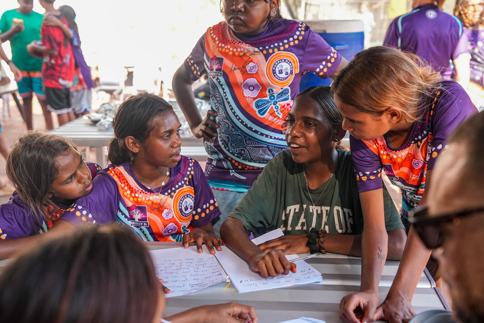 Students gathered around a desk working on a group assignment.