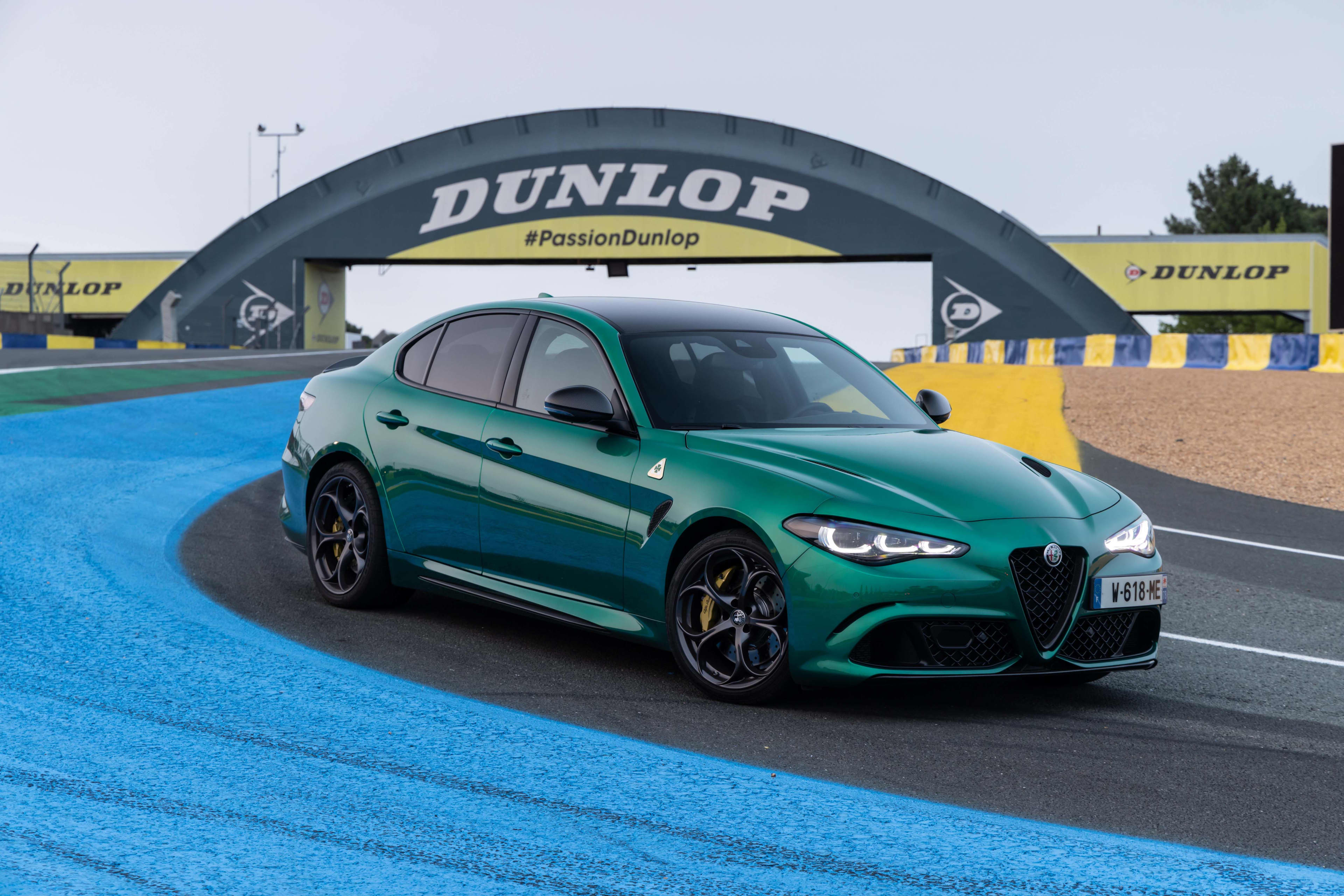A green Alfa Romeo Giulia on a race track