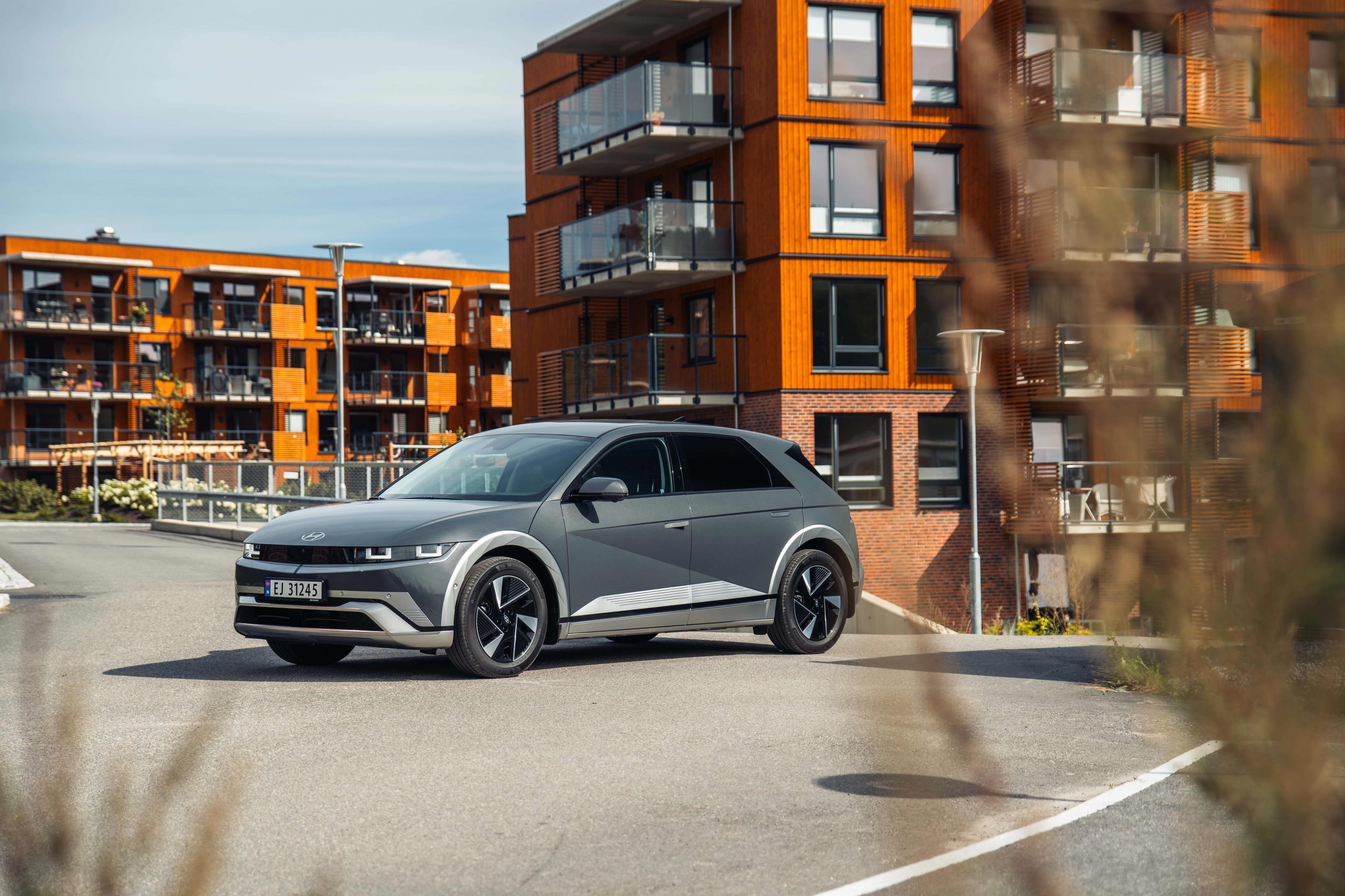 A grey Hyundai Ioniq parked outside some apartments