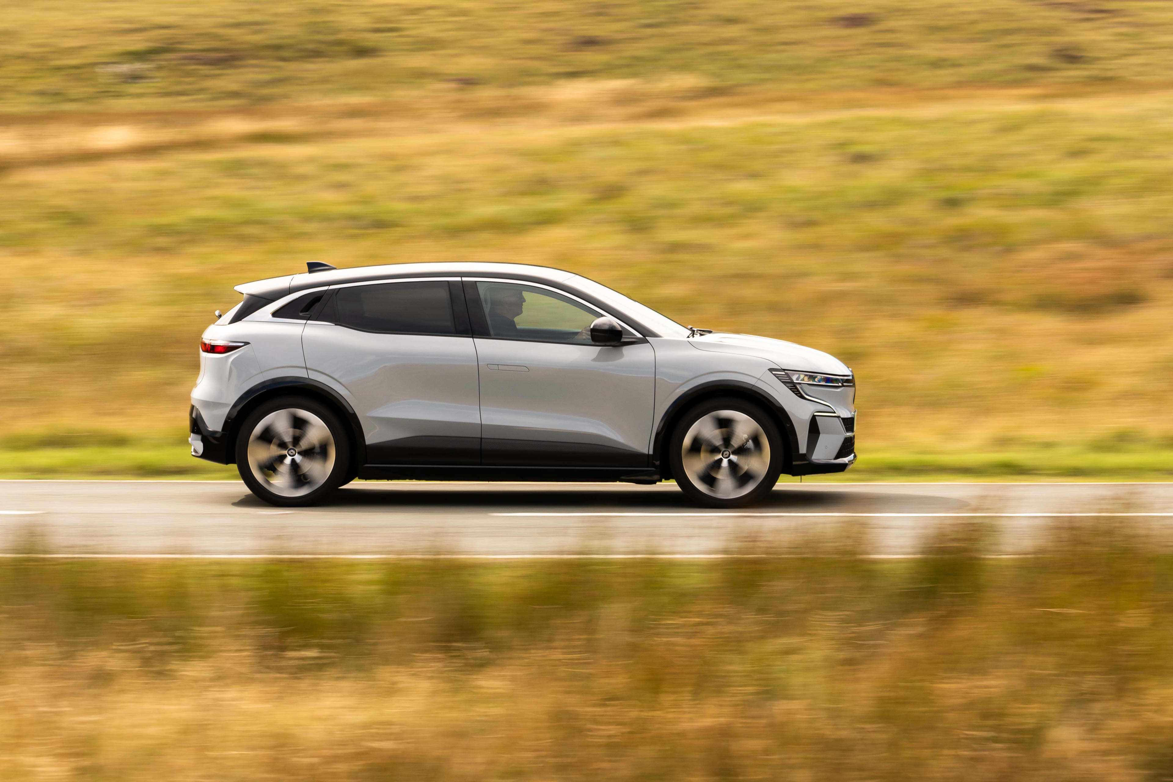 A white Best Renault Meganne driving on a country road