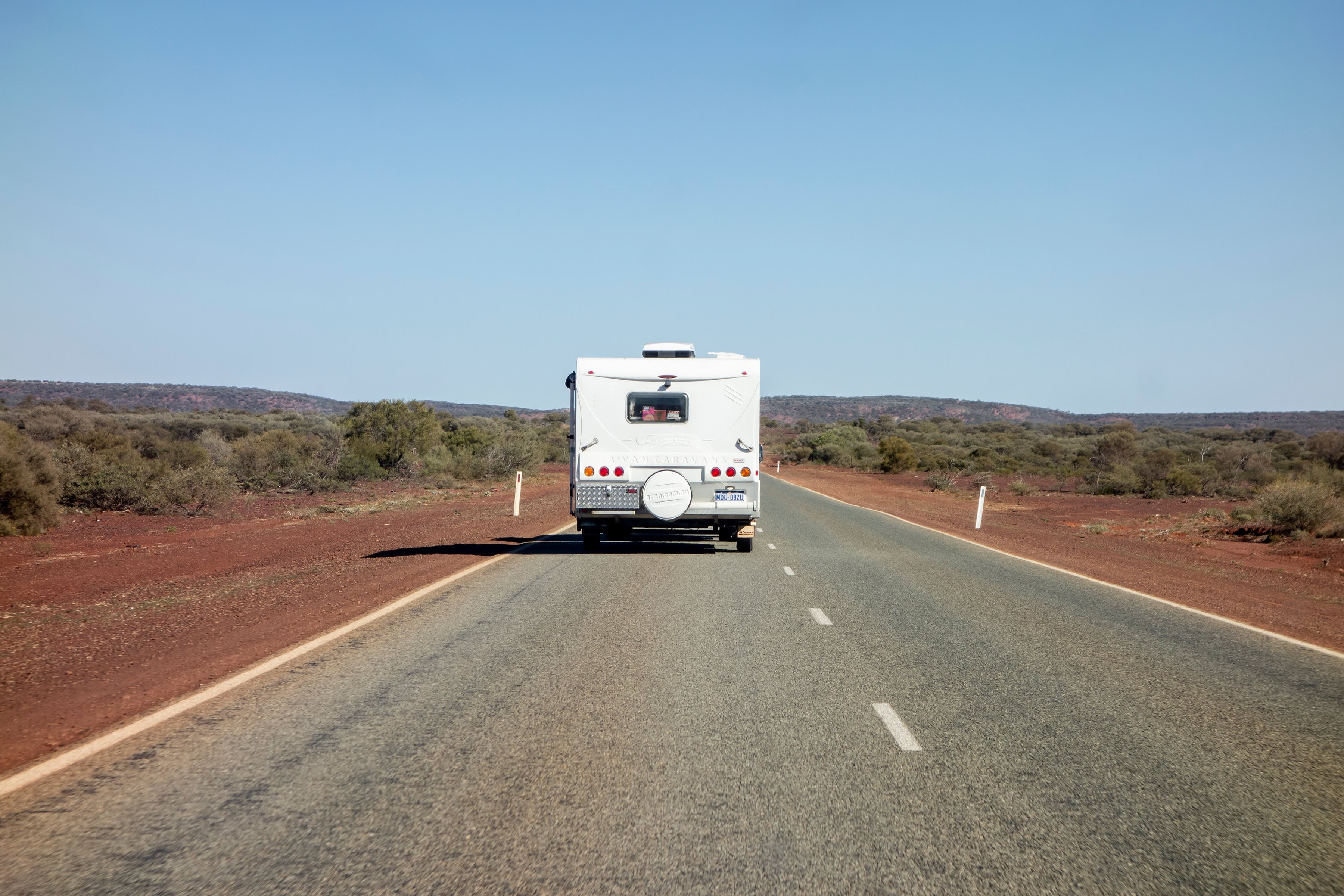 The rear of a caravan travelling on a remote road