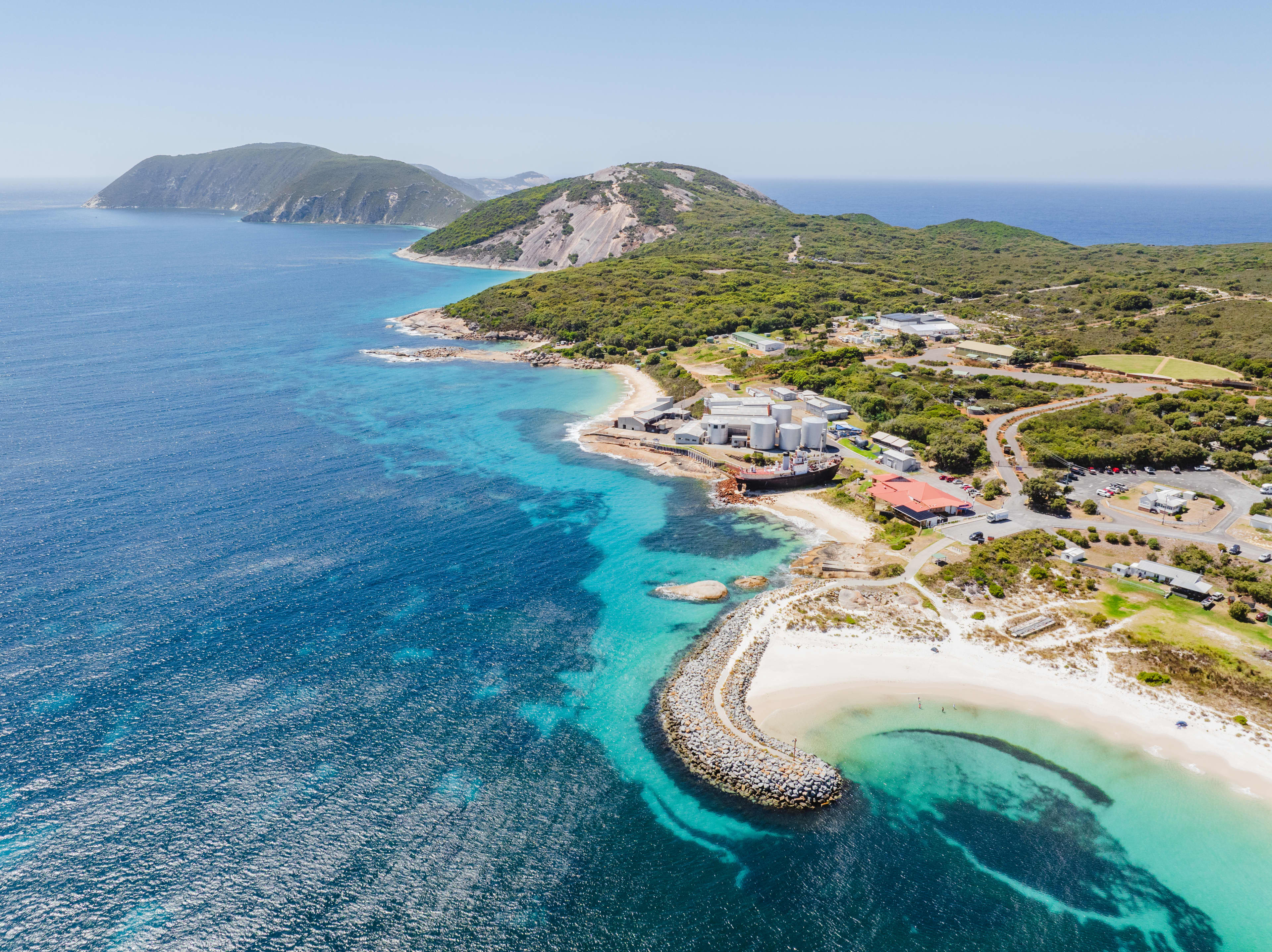 A town with large granite outcrops surrounded by turquoise blue water.