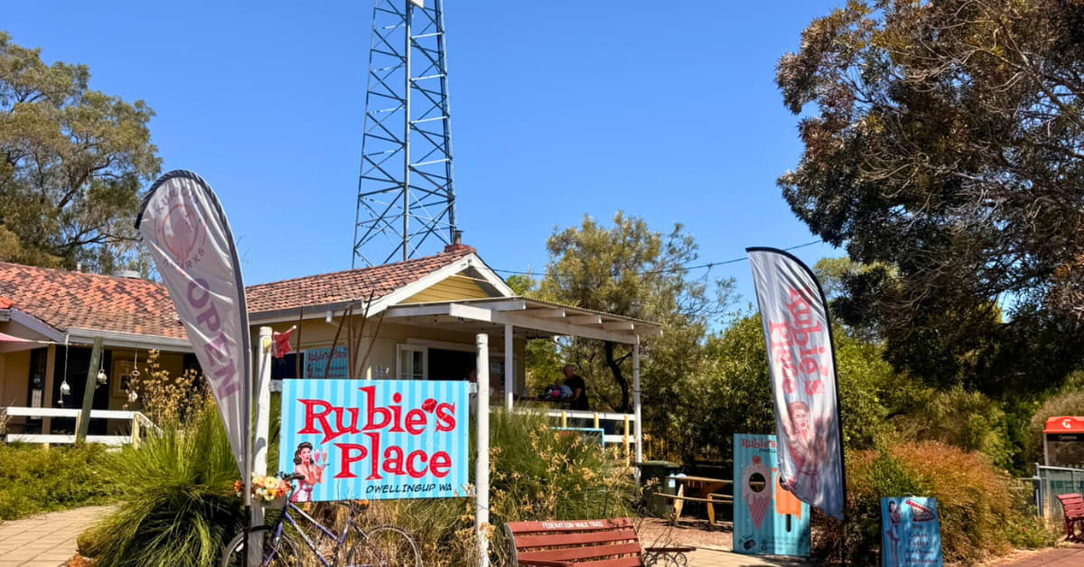 The view of Rubie's Place cafe from the street. A small house with verandah and signs advertising business Rubie's Place.