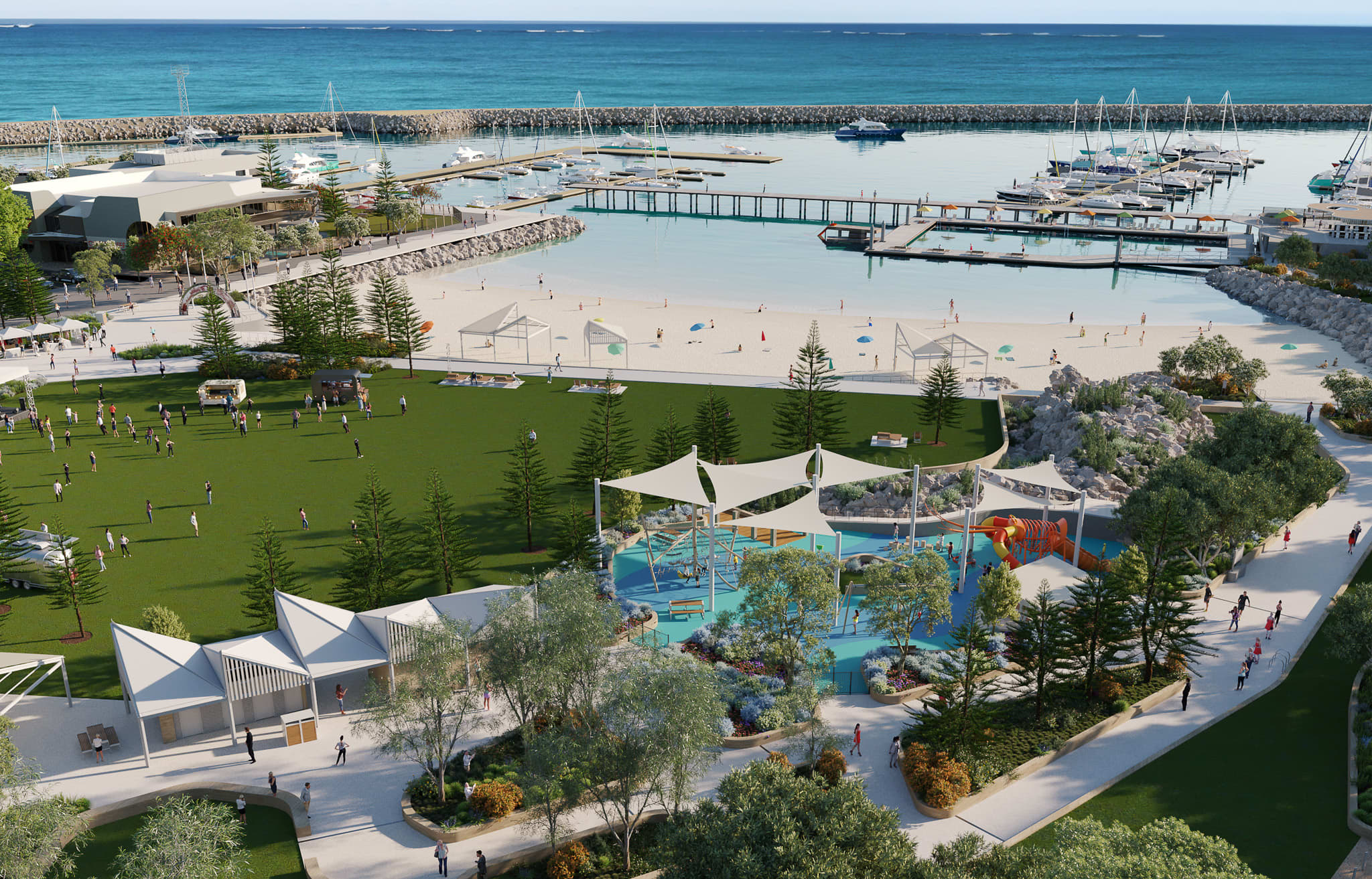 An aerial view of a marina development featuring a large grass area, sheltered beach access, and a sheltered playground.
