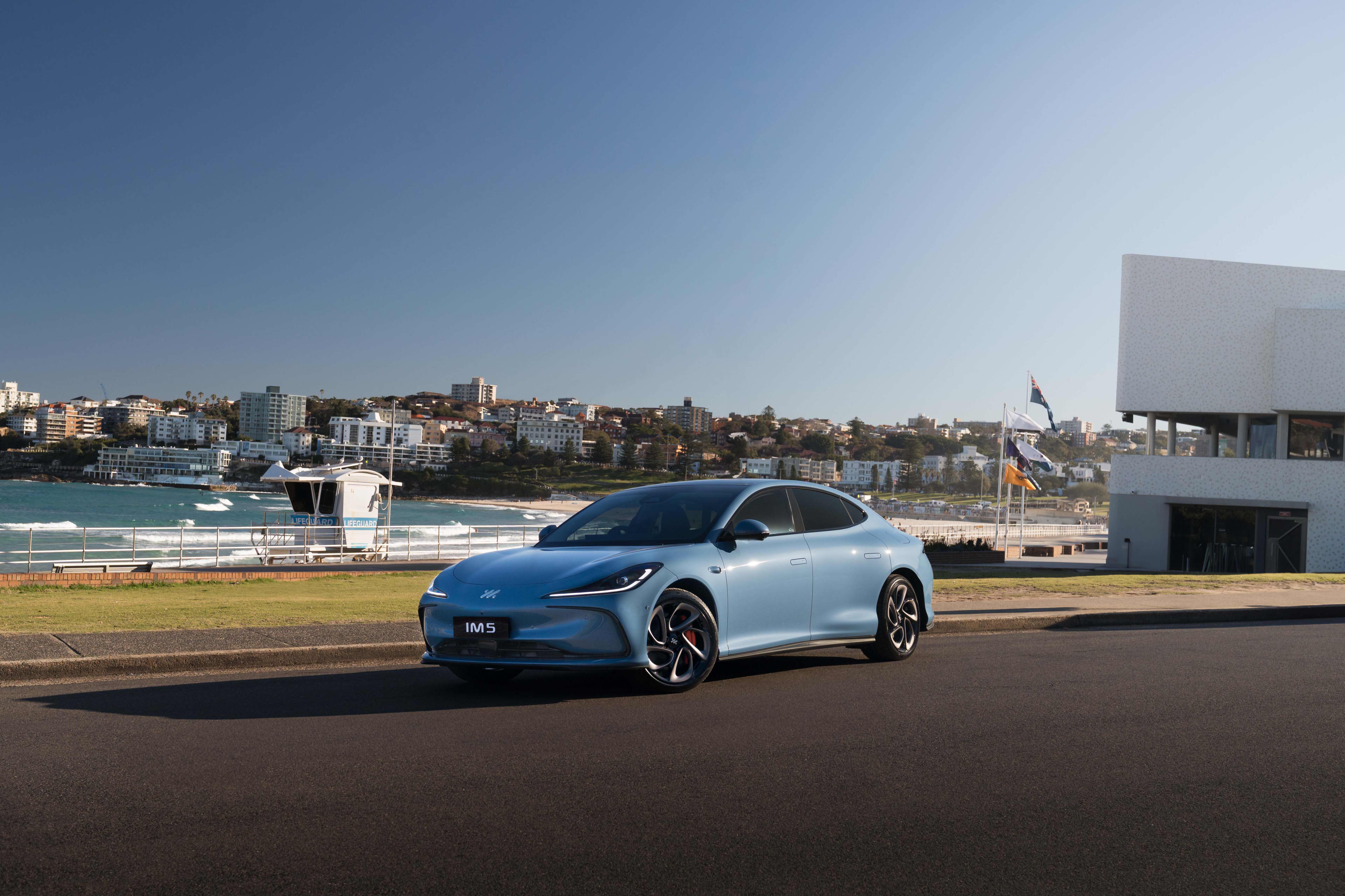 A light blue IM_IM5 parked near a beach