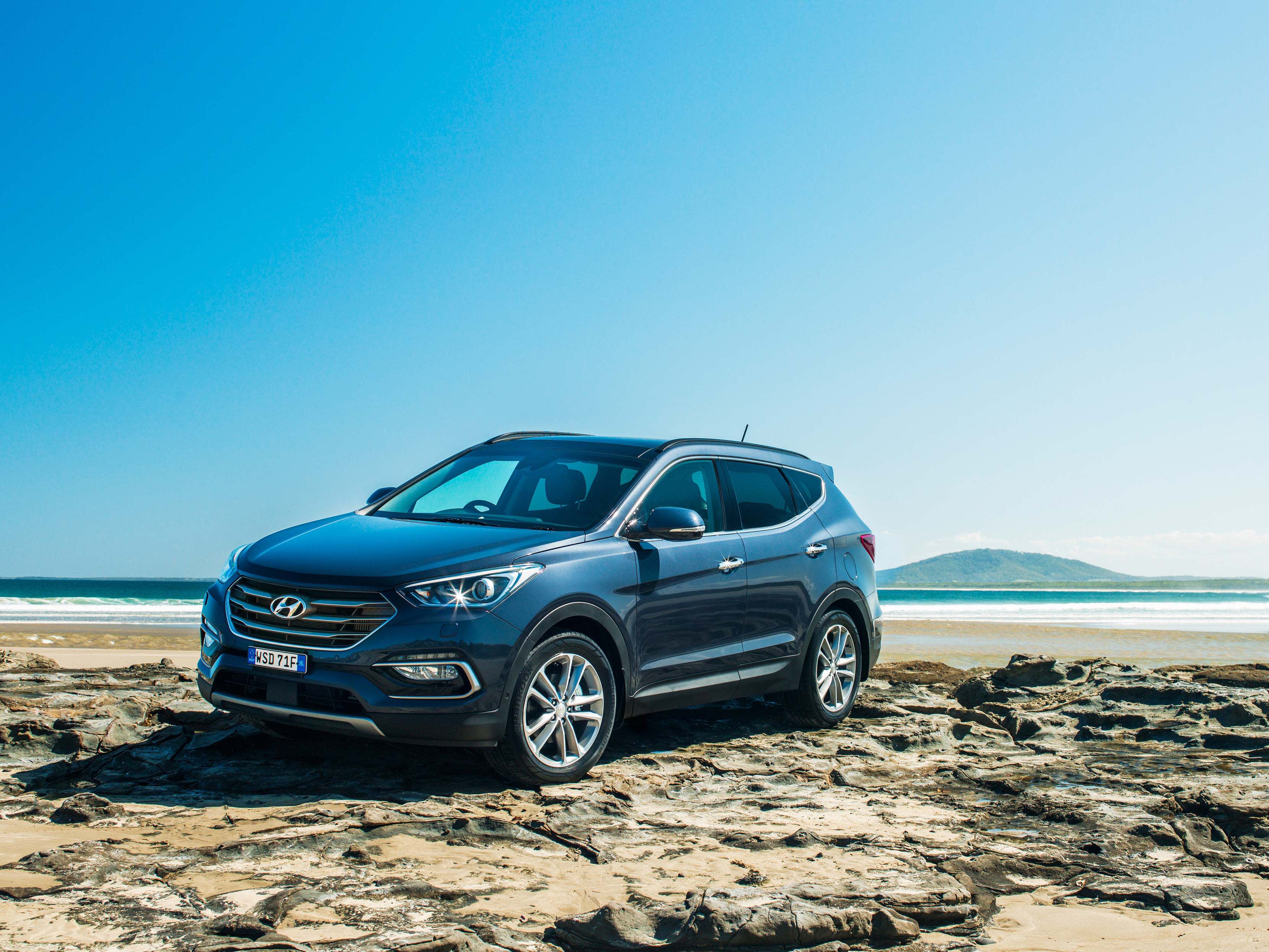 A black Hyundai DM Santa Fe parked on a beach