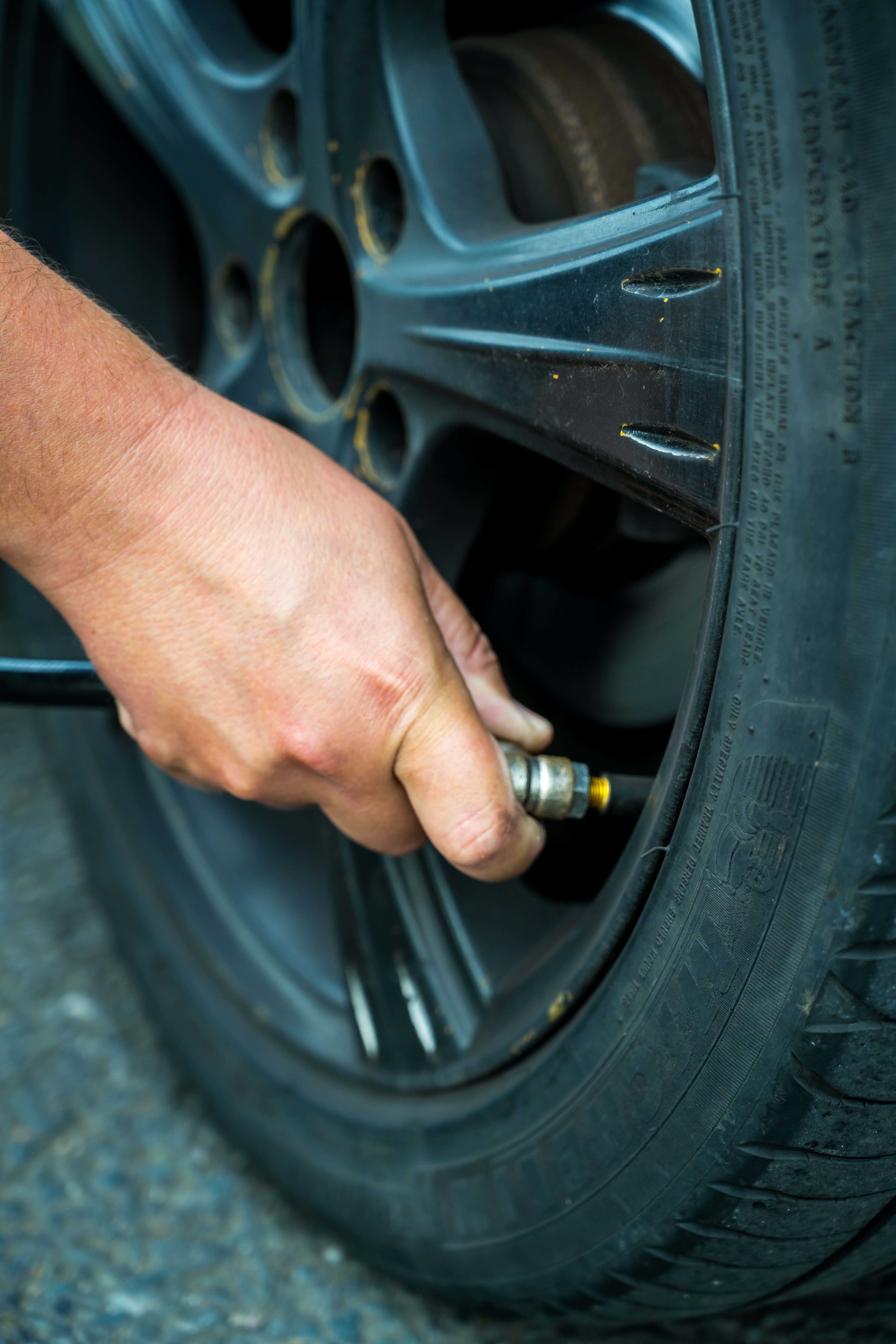 A close up of someone putting air into a tyre