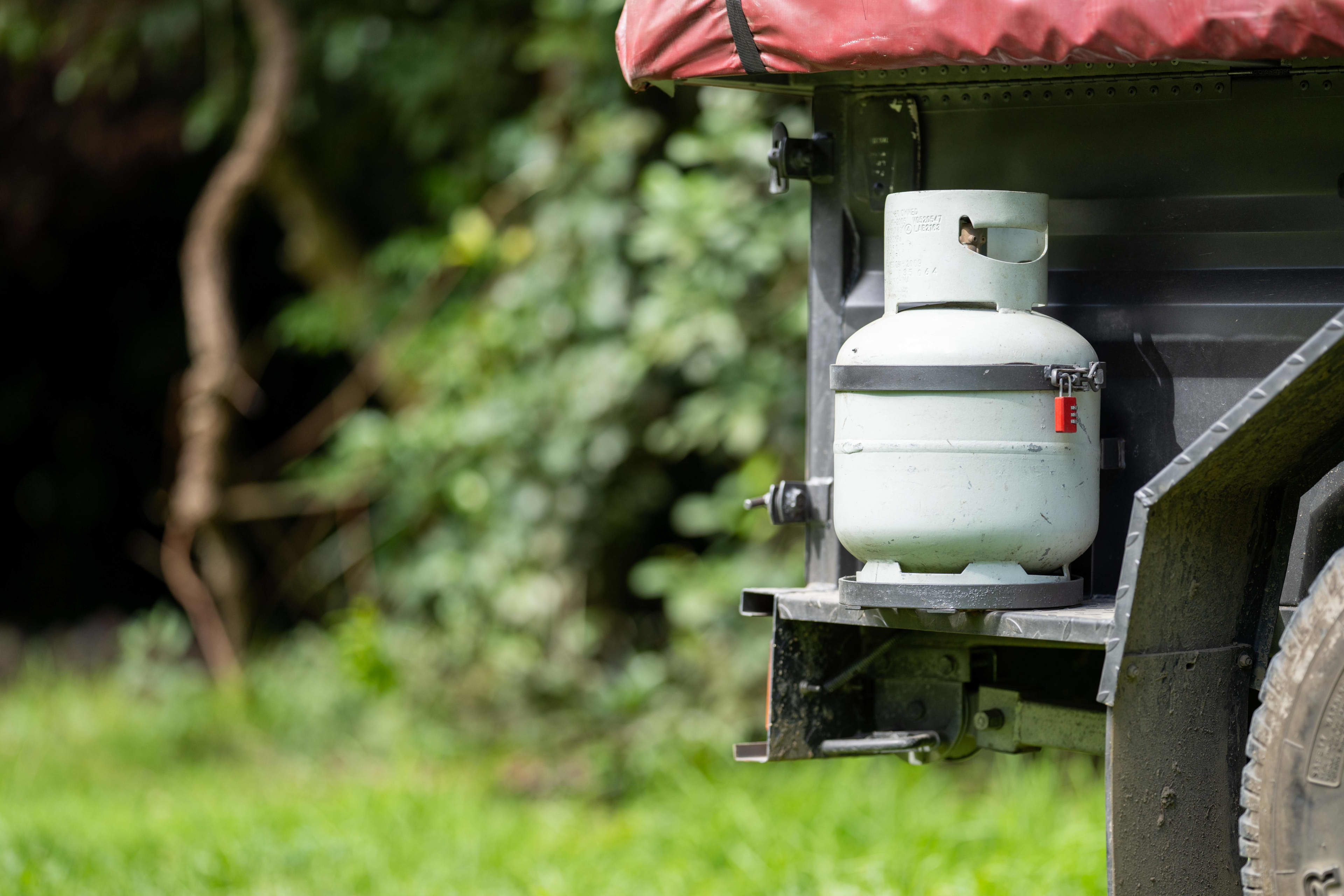 A gas bottle fixed to the rear of a camper trailer
