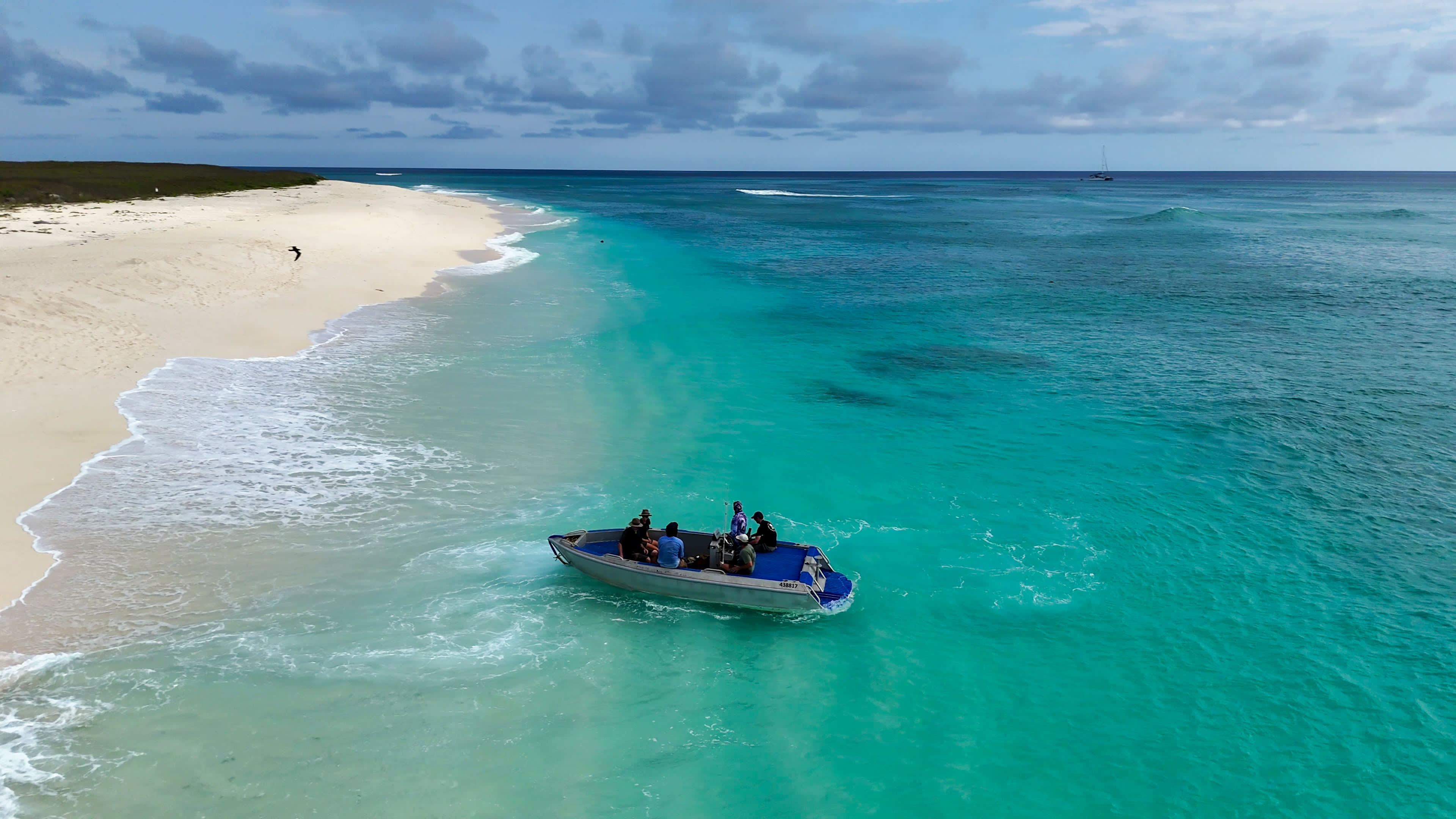 Boat arriving on turquoise shores of Browse Island.