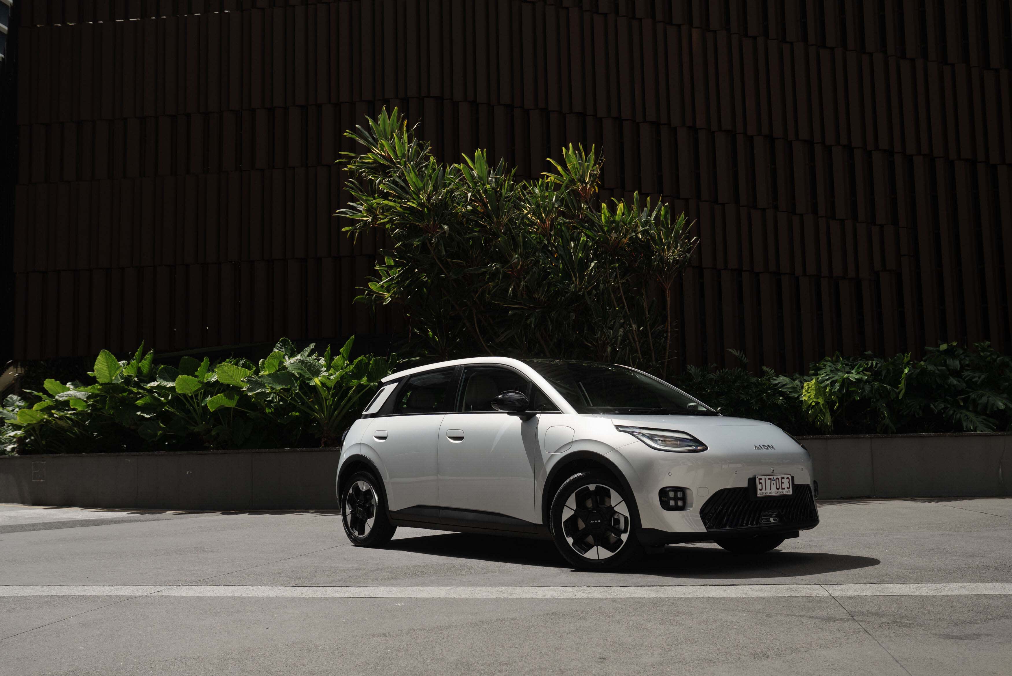 A white GAC AION UT EV parked on a city street