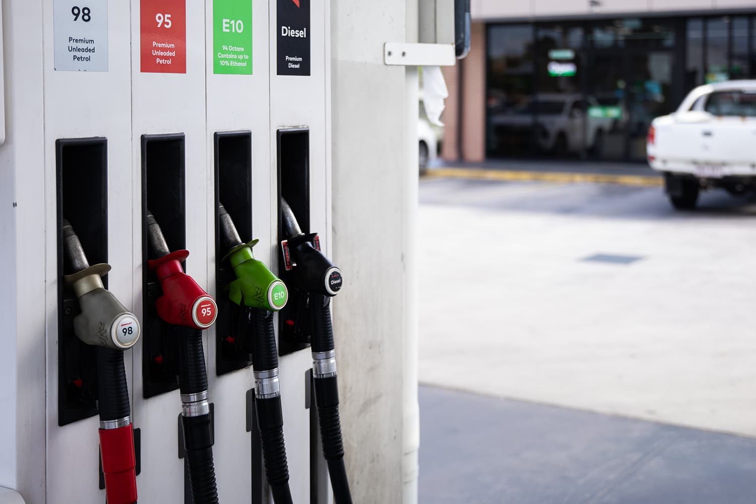 A row of fuel pump handles at a fuel station