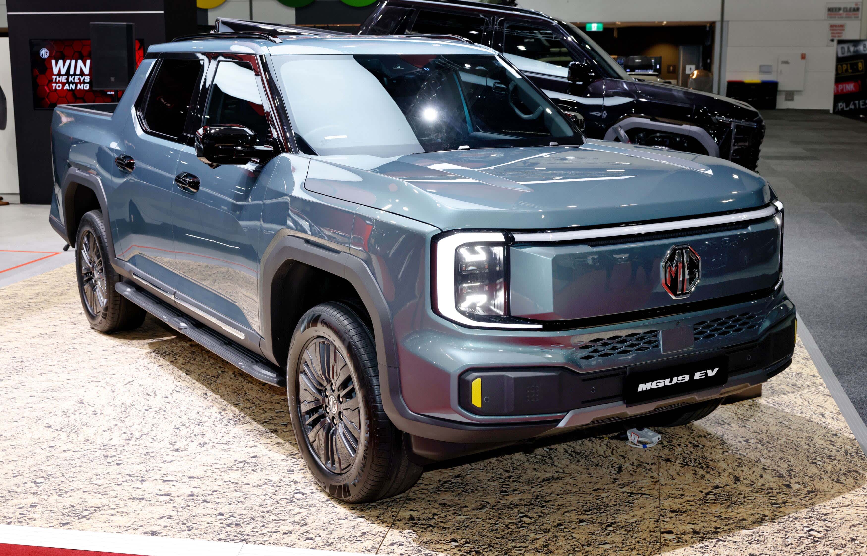 A blue grey 6 MG U9 EV ute on a display stand