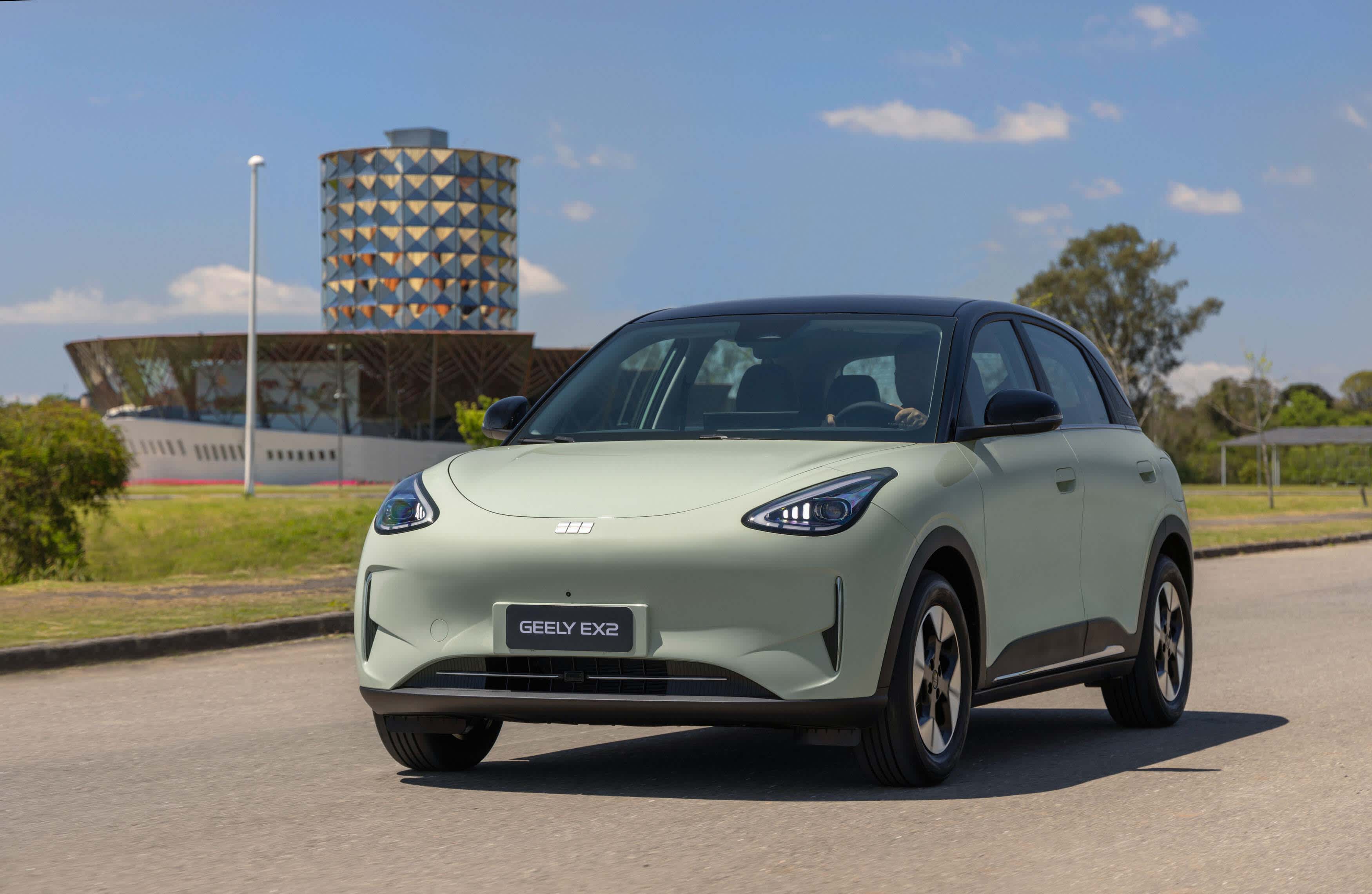 A light green Geely EX2_ev on a city road