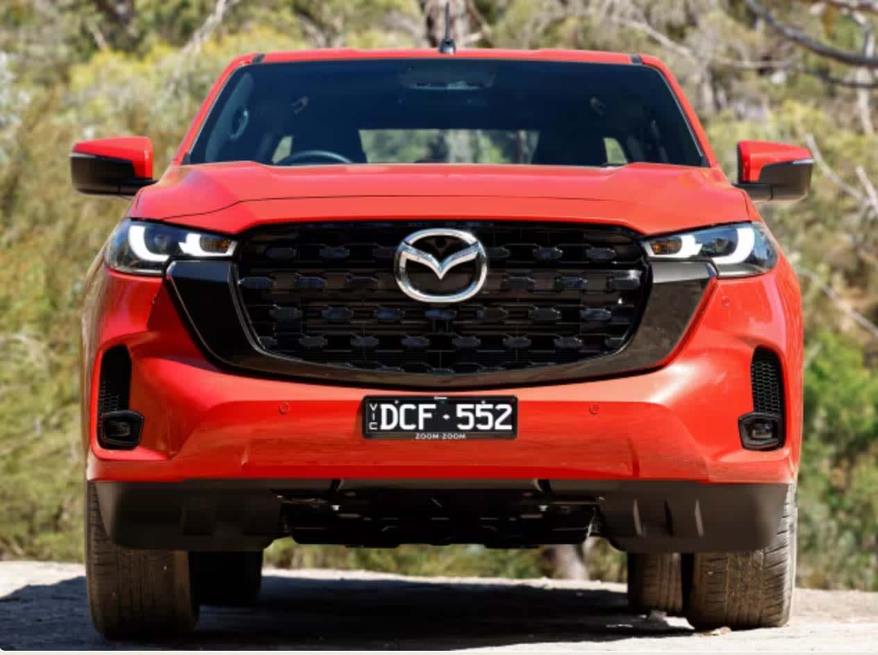 A red Mazda BT-50 2.2L parked on a country road