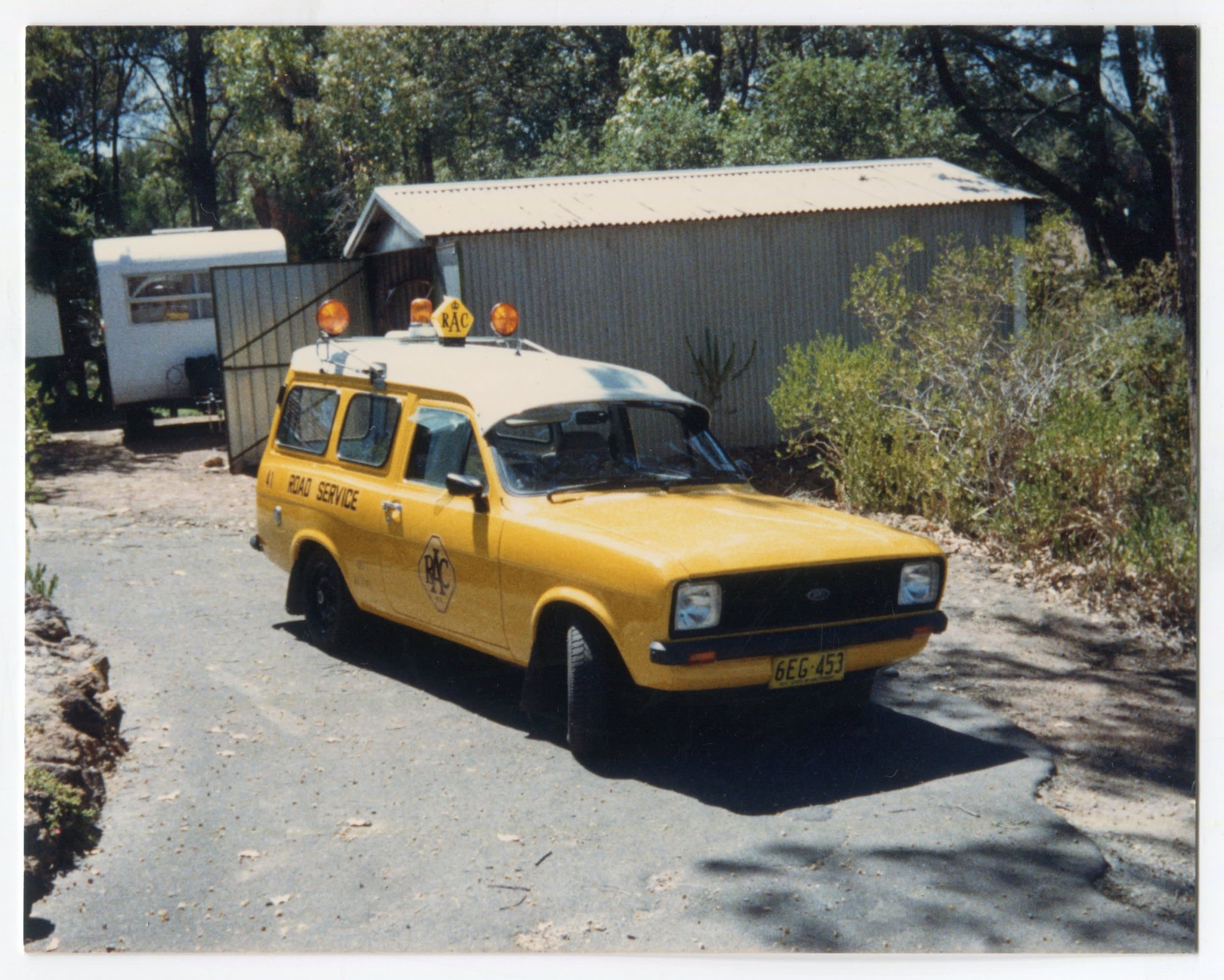 A yellow Ford Escort patrol car parked on a driveway