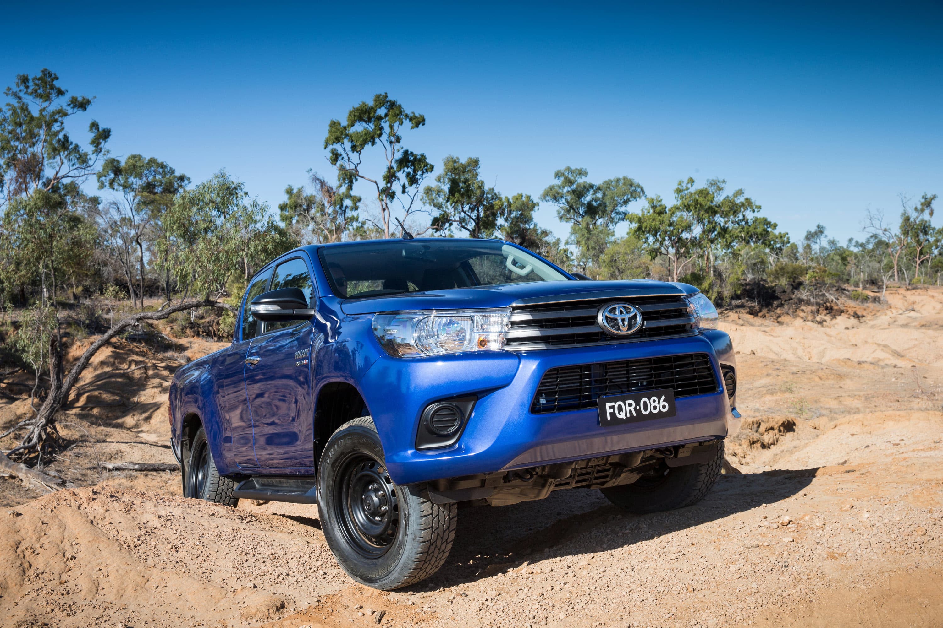 A blue 2016 Toyota Hilux on a steep dirt track