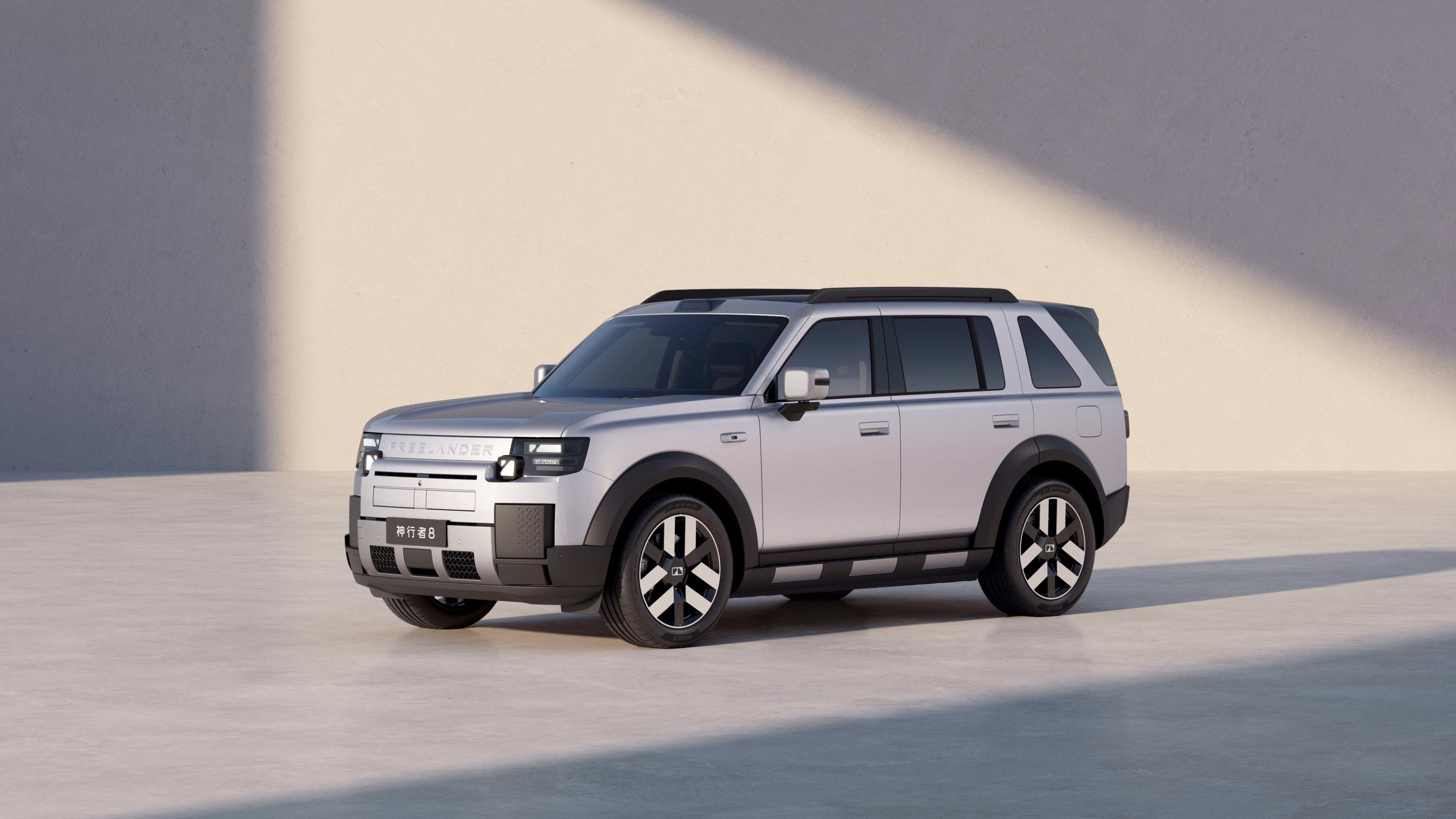 A silver Chery Freelander against a white wall
