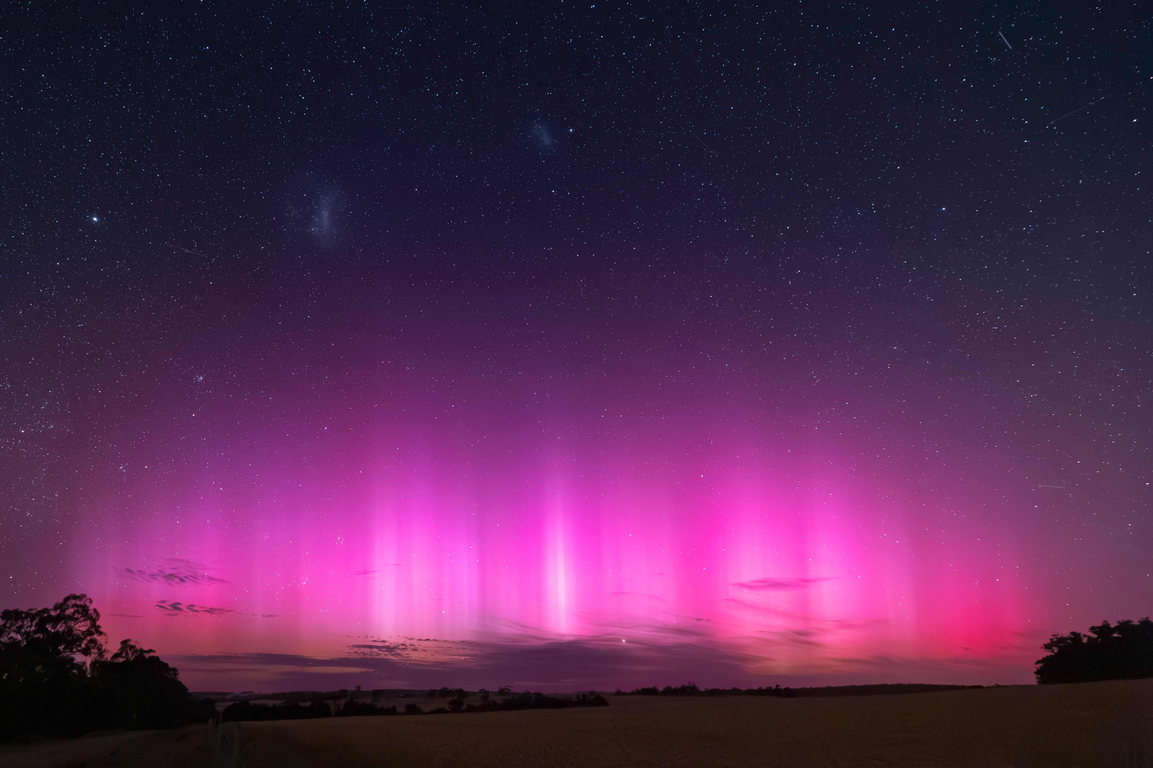 Bright pink lights from Aurora Australis over a paddock