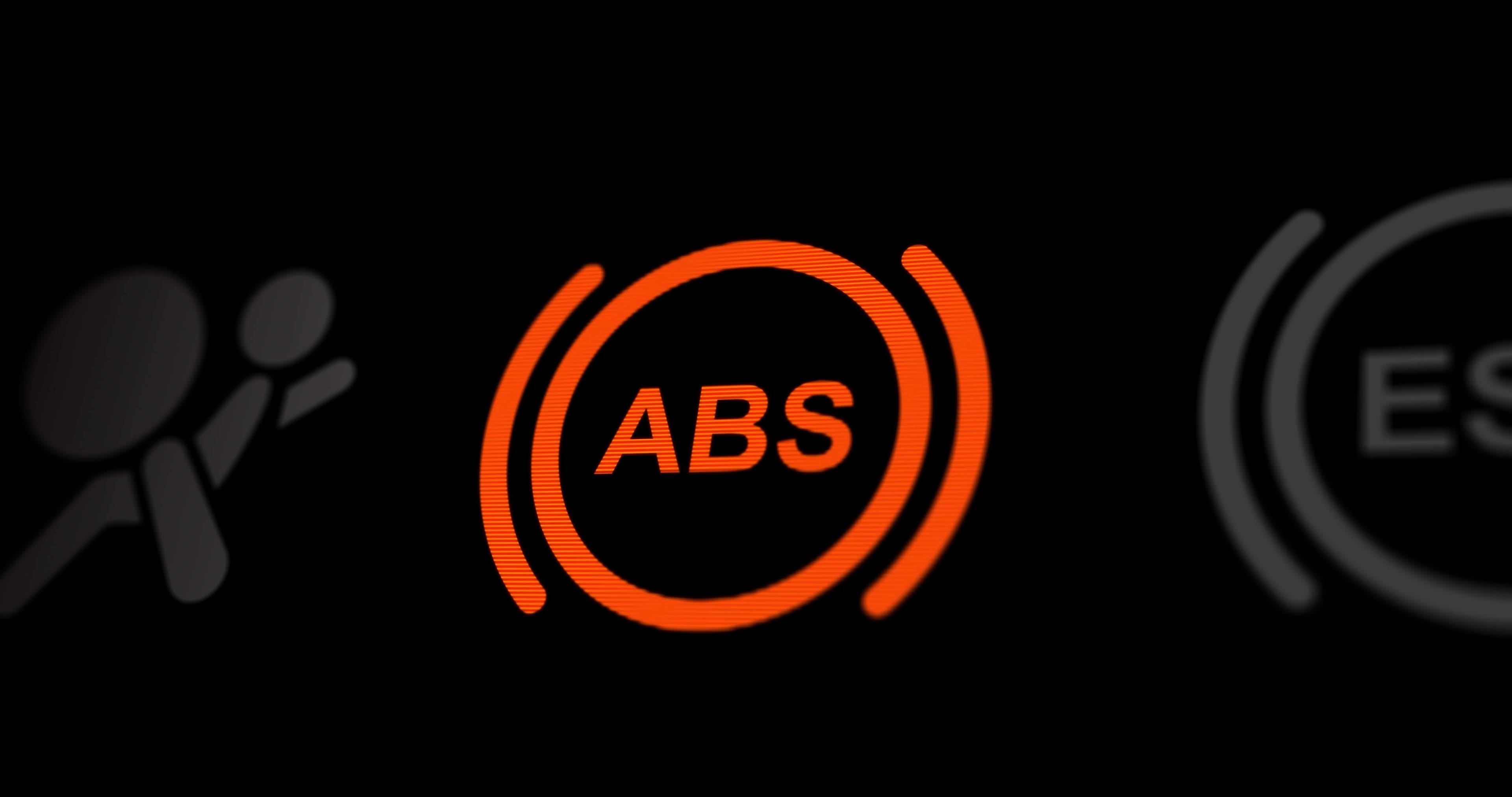 An ABS button lit up on a car dashboard