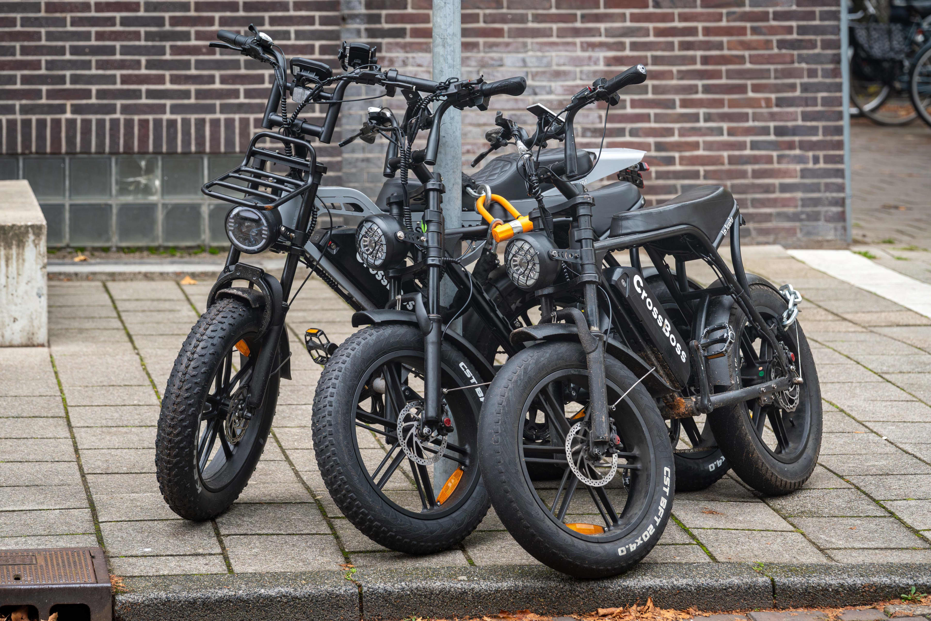 A group of ebikes leaning together that resemble motorbikes
