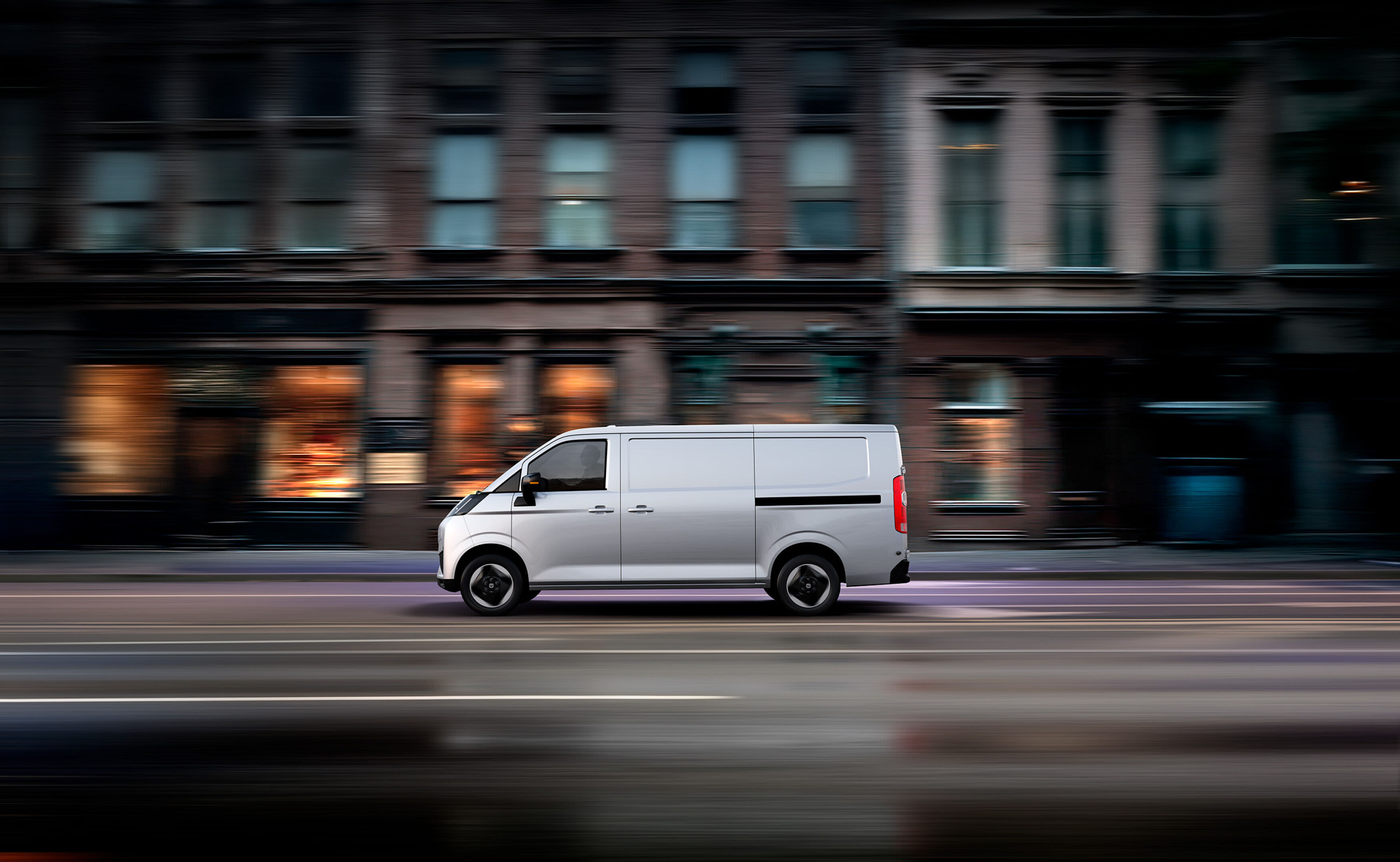 A white van in motion on a city street