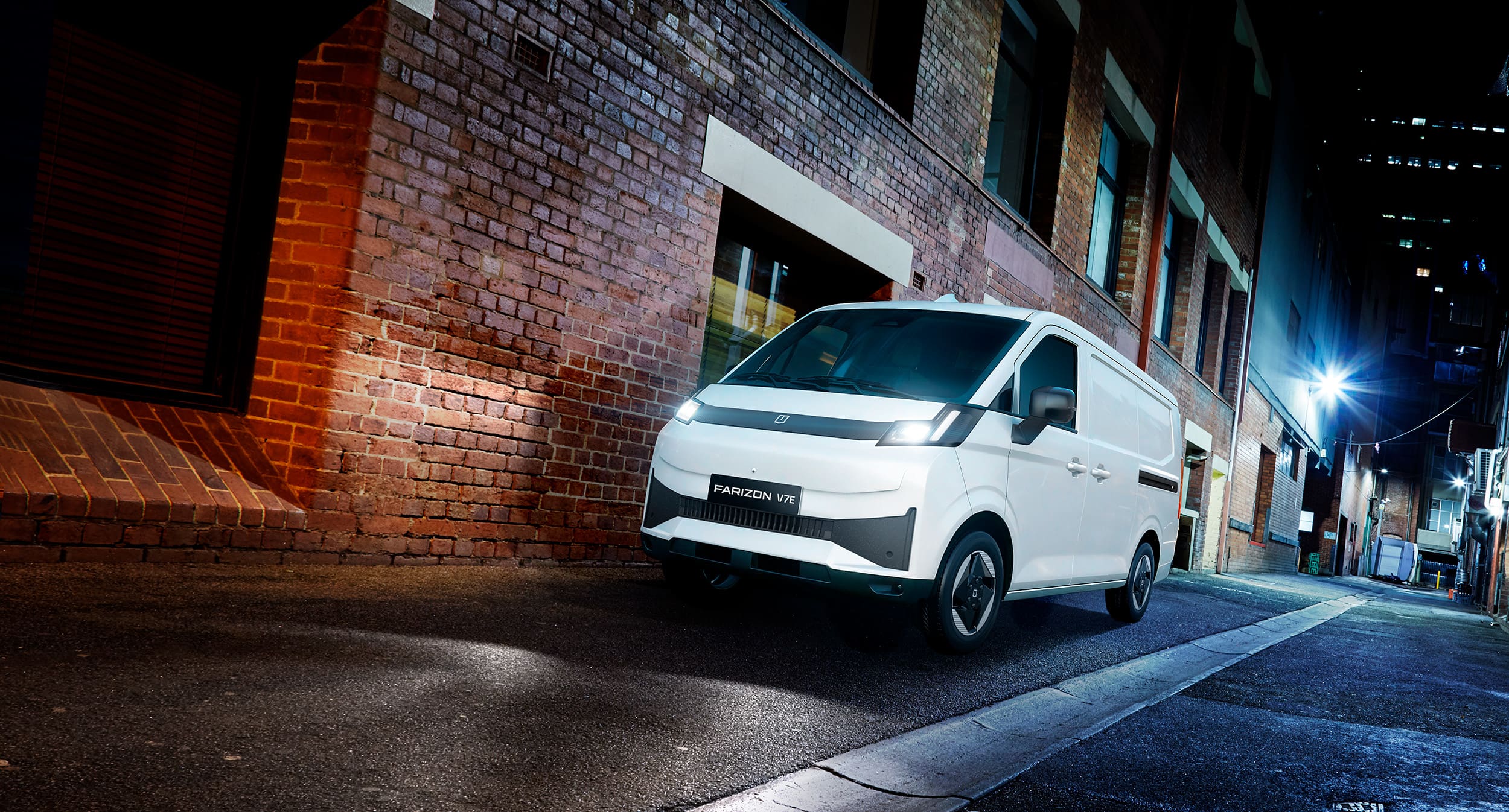 A white Farizon V7E EV van parked in a city laneway at night