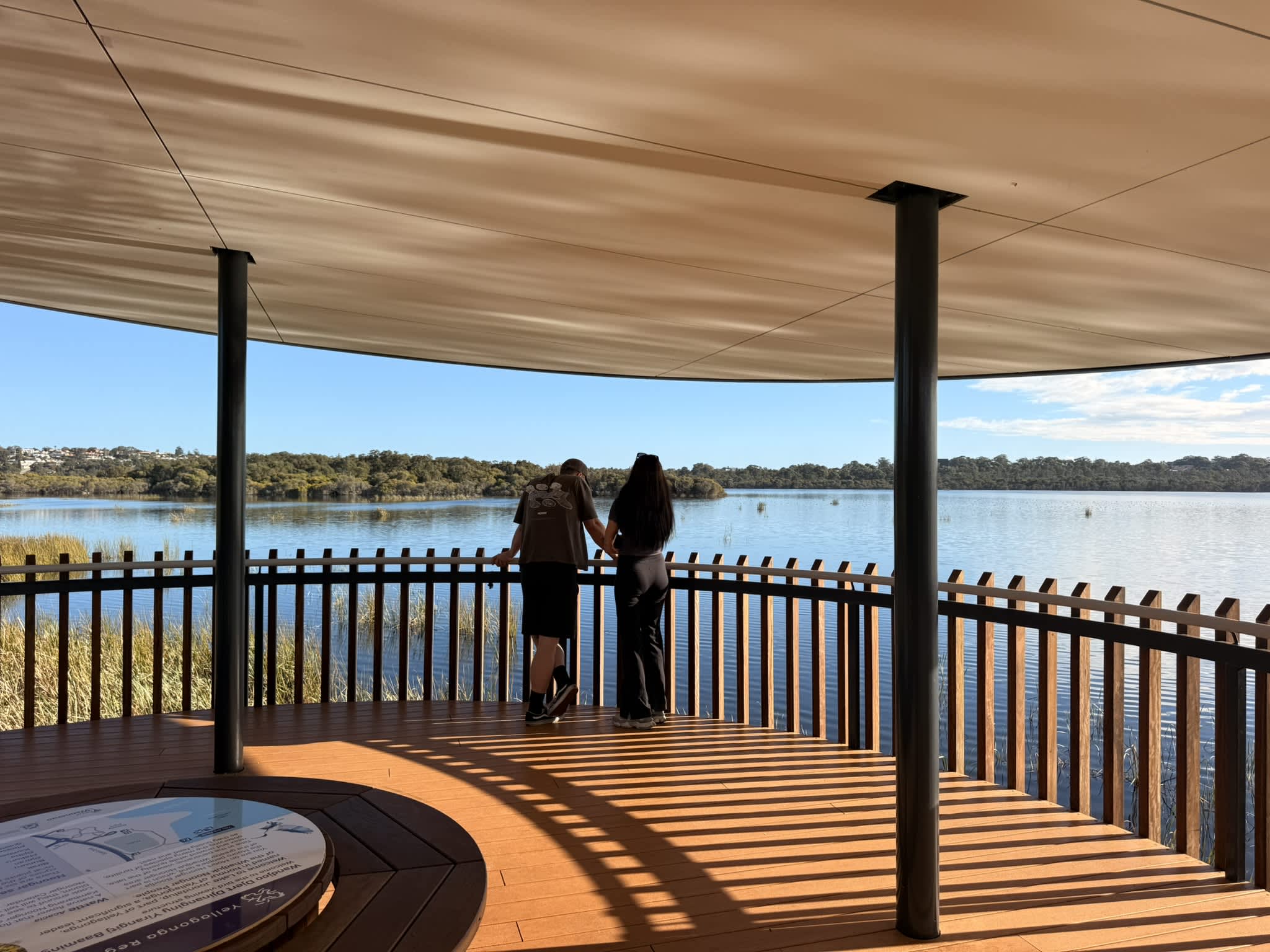 A couple looking out across lake for birds inside a tower.