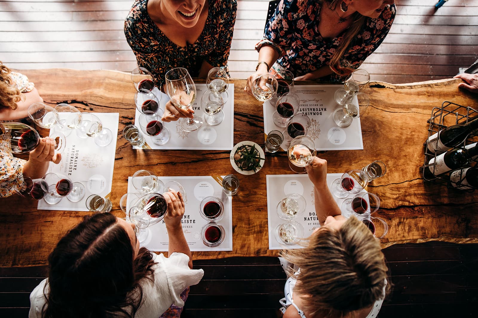 Group of people around a table doing wine pairing course.