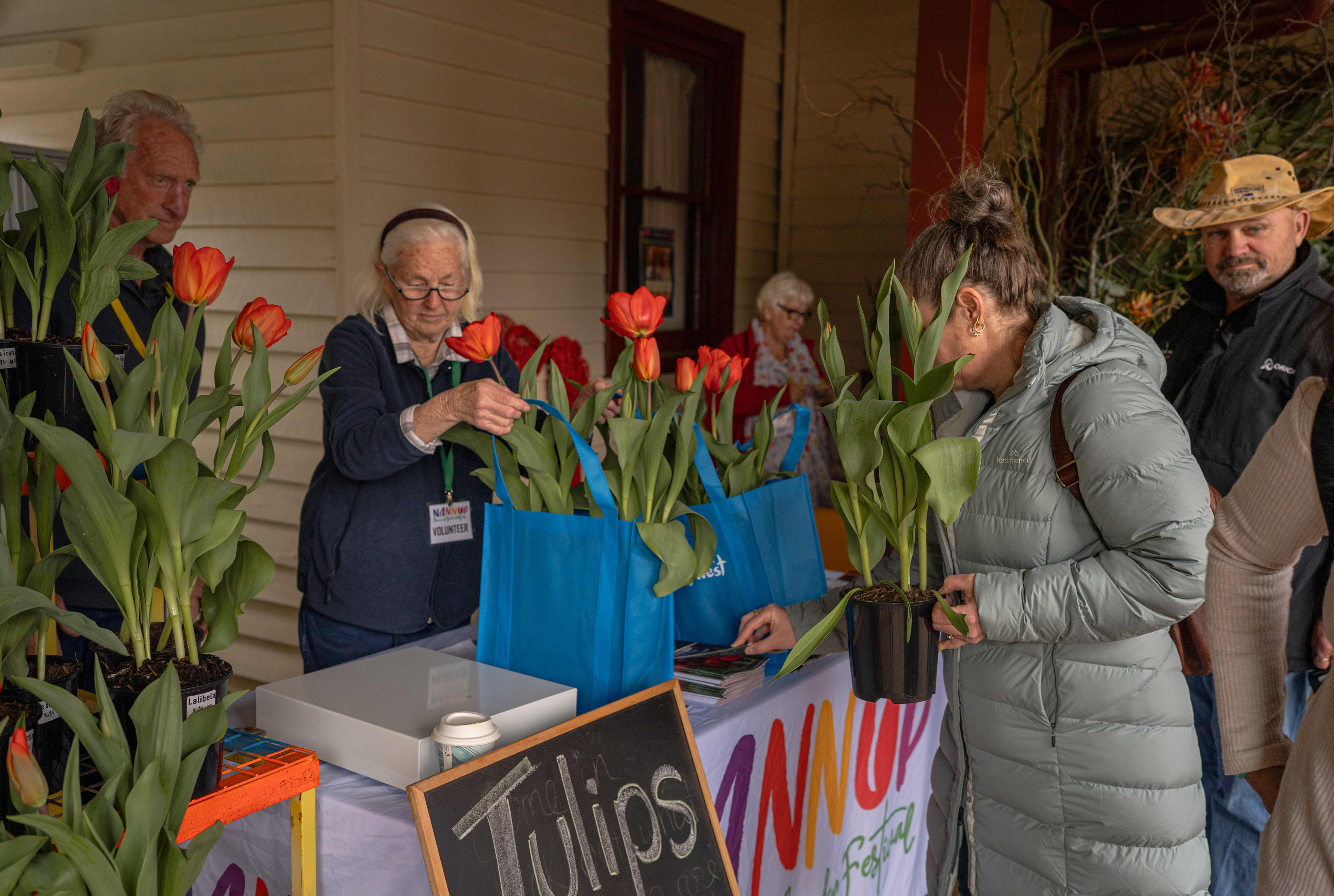 People browse a table filled with tulips