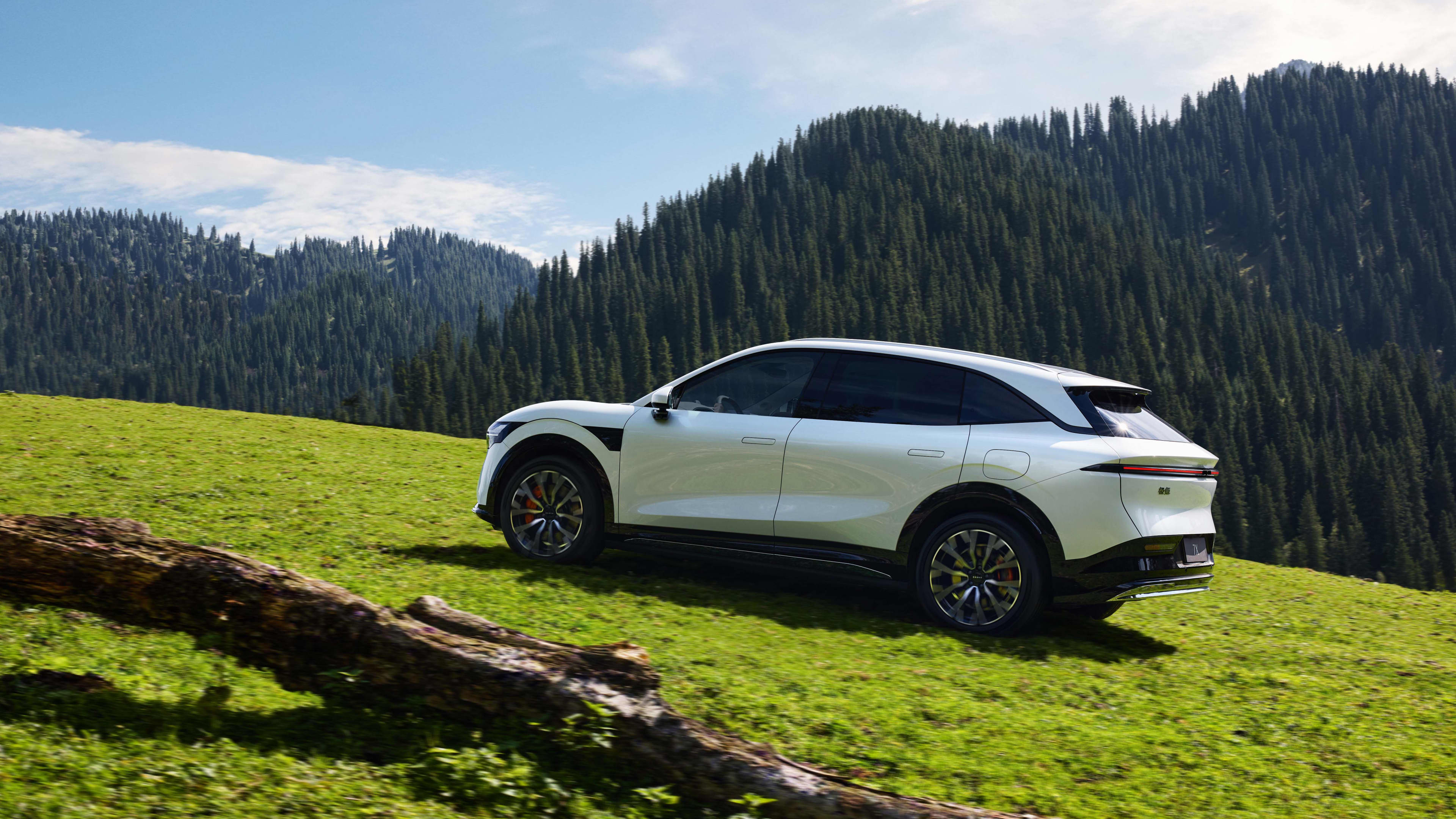 A white Zeekr 7x on a green hillside