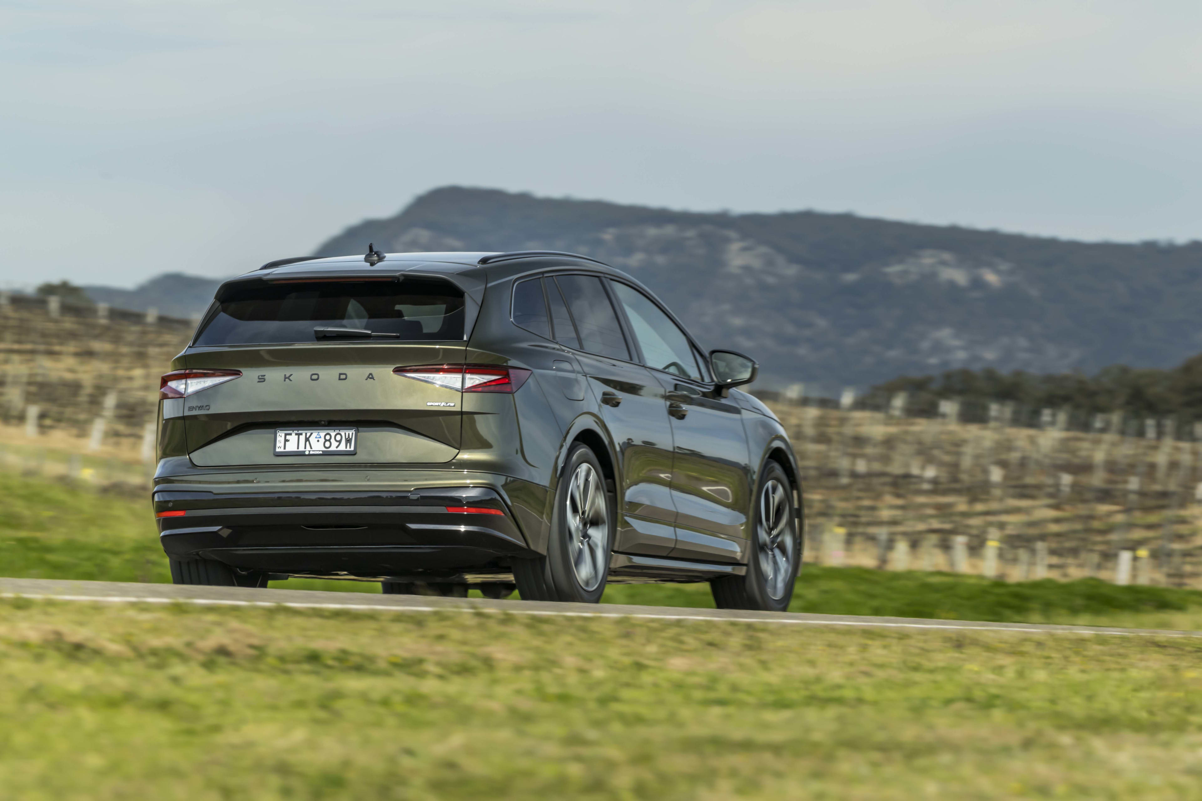 A green Skoda Enyaq EV SUV near a vineyard