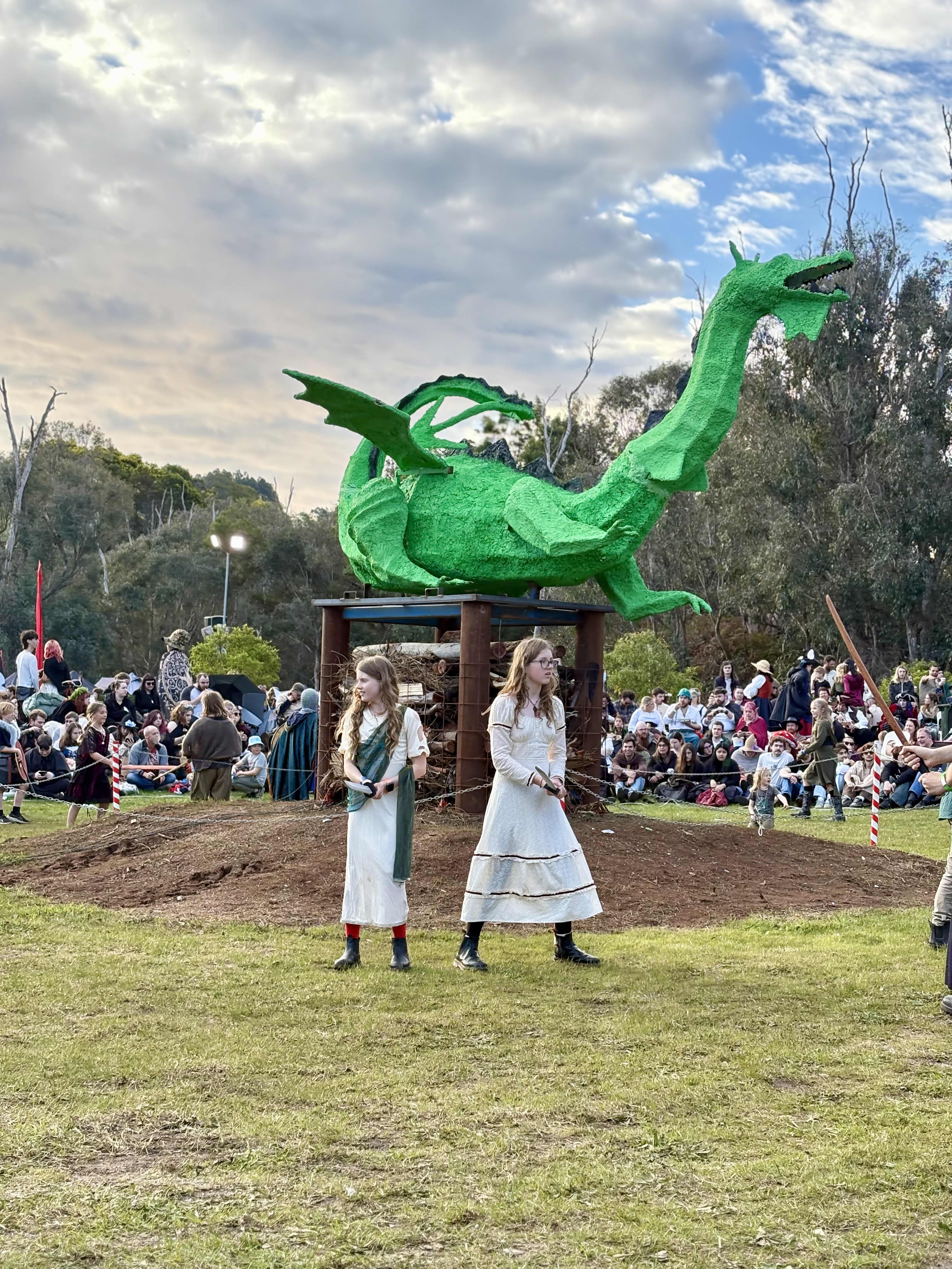 Two girls in front of large dragon dressed in period costume