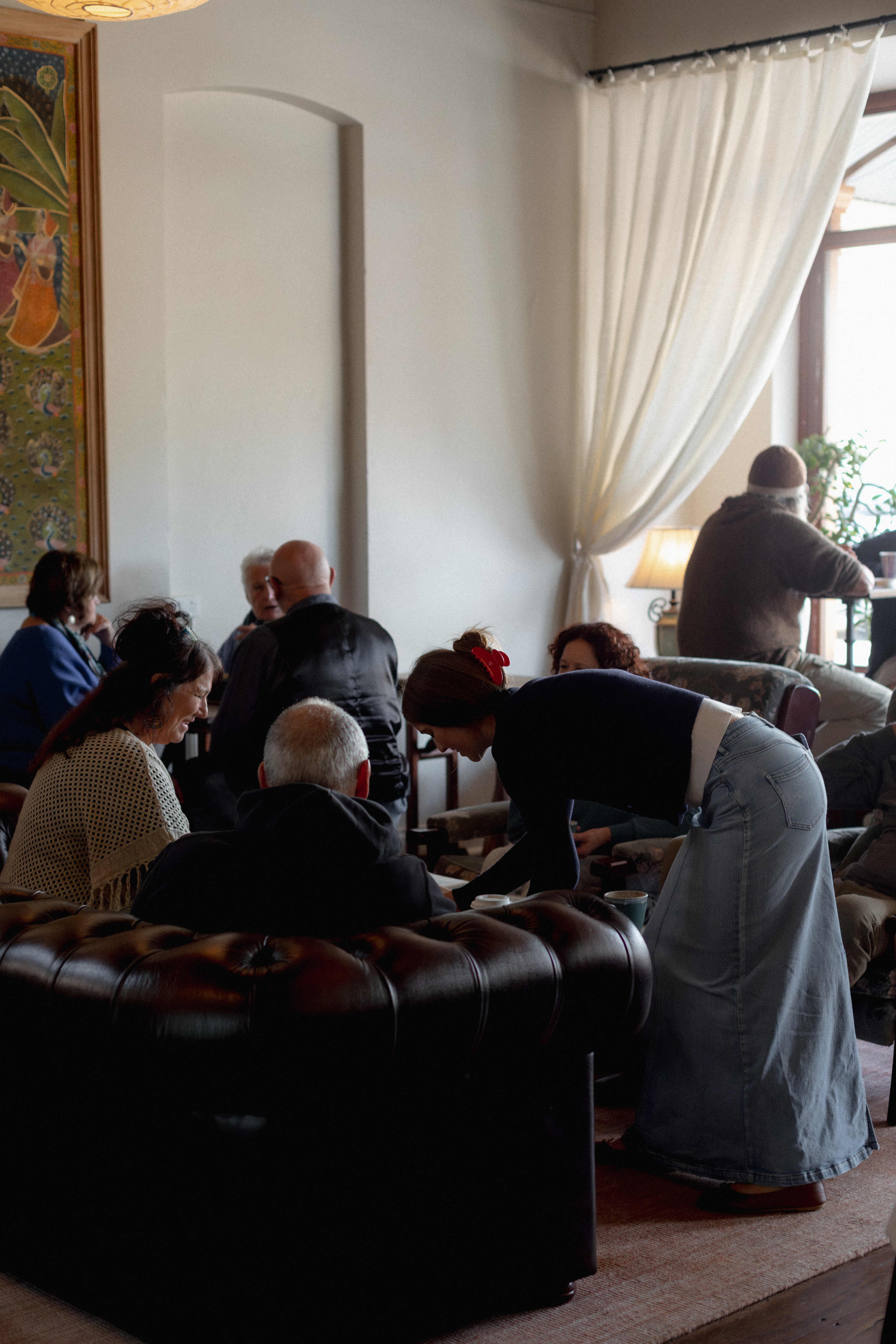 Crowd of people sitting in lounges drinking coffee inside cafe