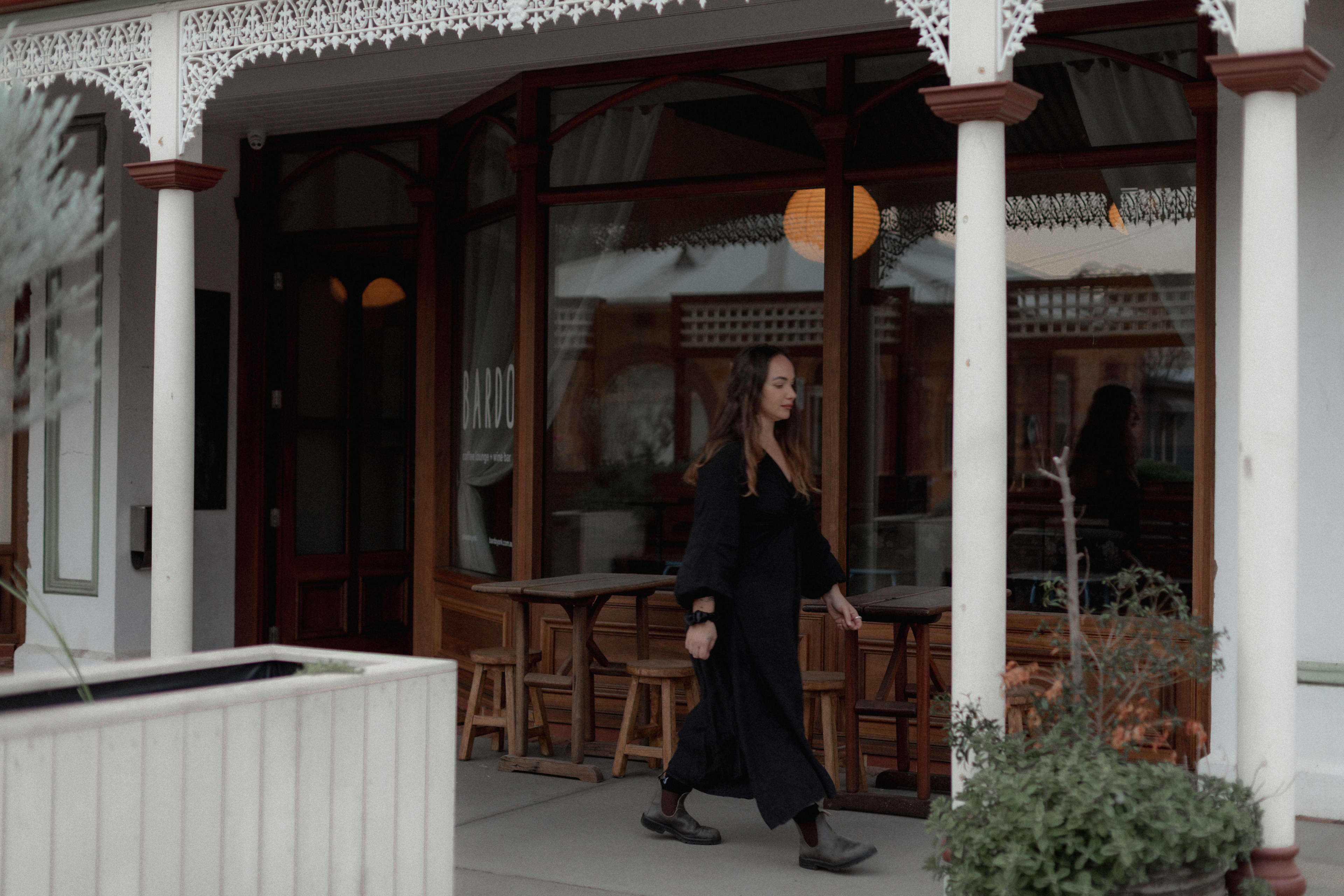 Woman walking past Bardo coffee shopfront on main street.