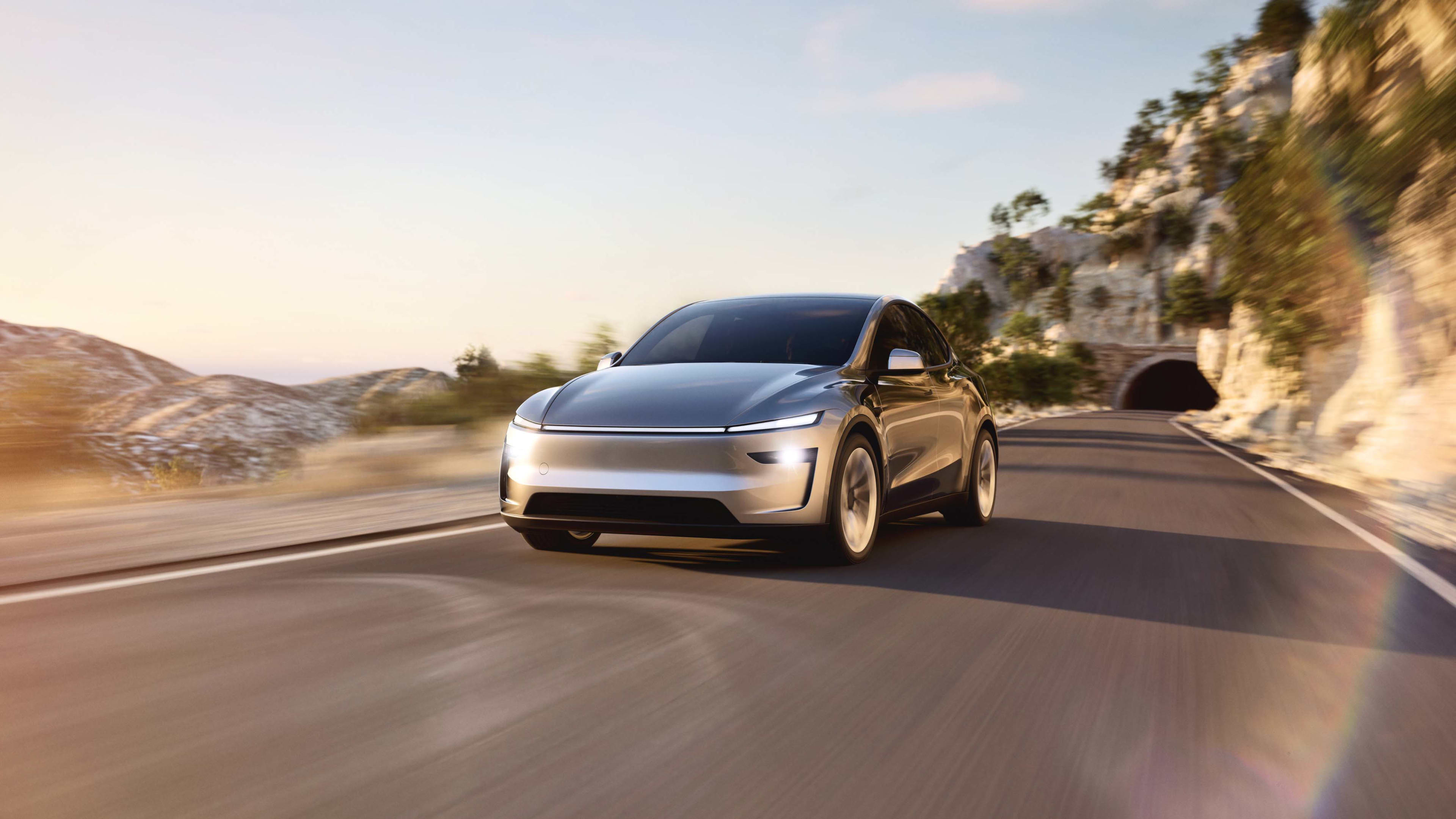 A silver Tesla Model Y on a mountainous road