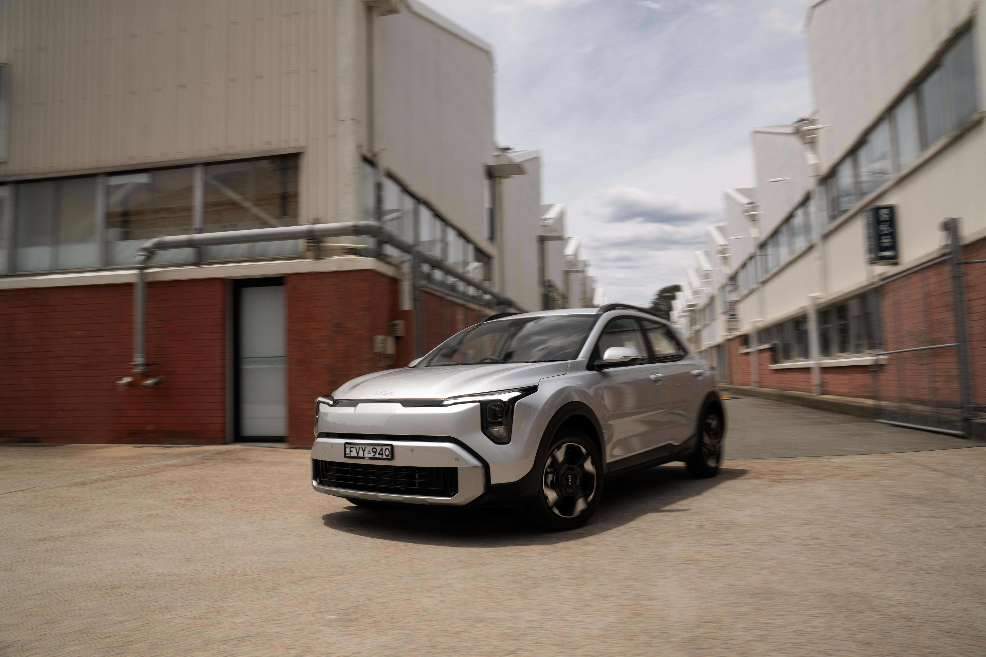 A silver Kia Stonic parked near warehouses
