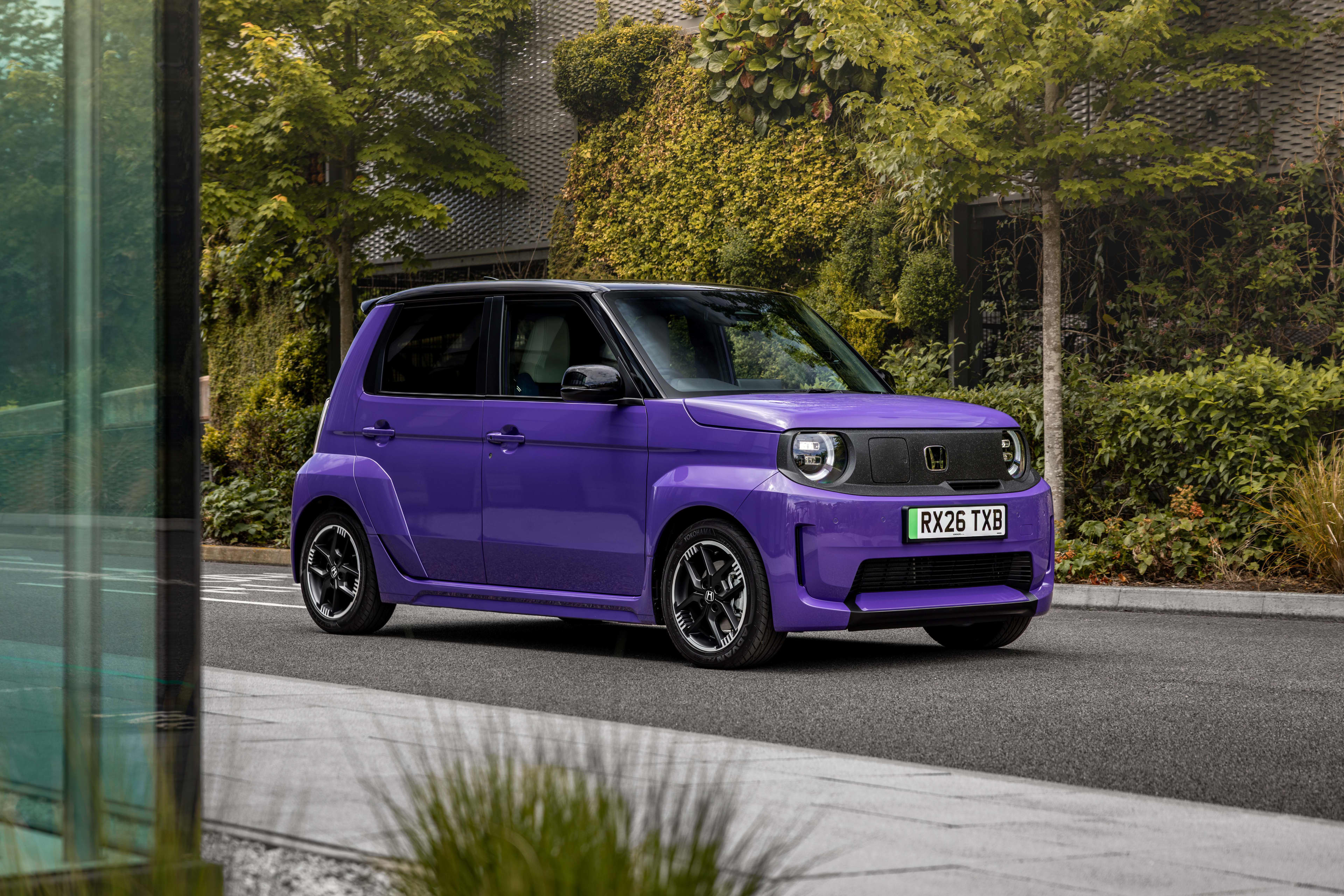 A purple Honda super one EV on a suburban street