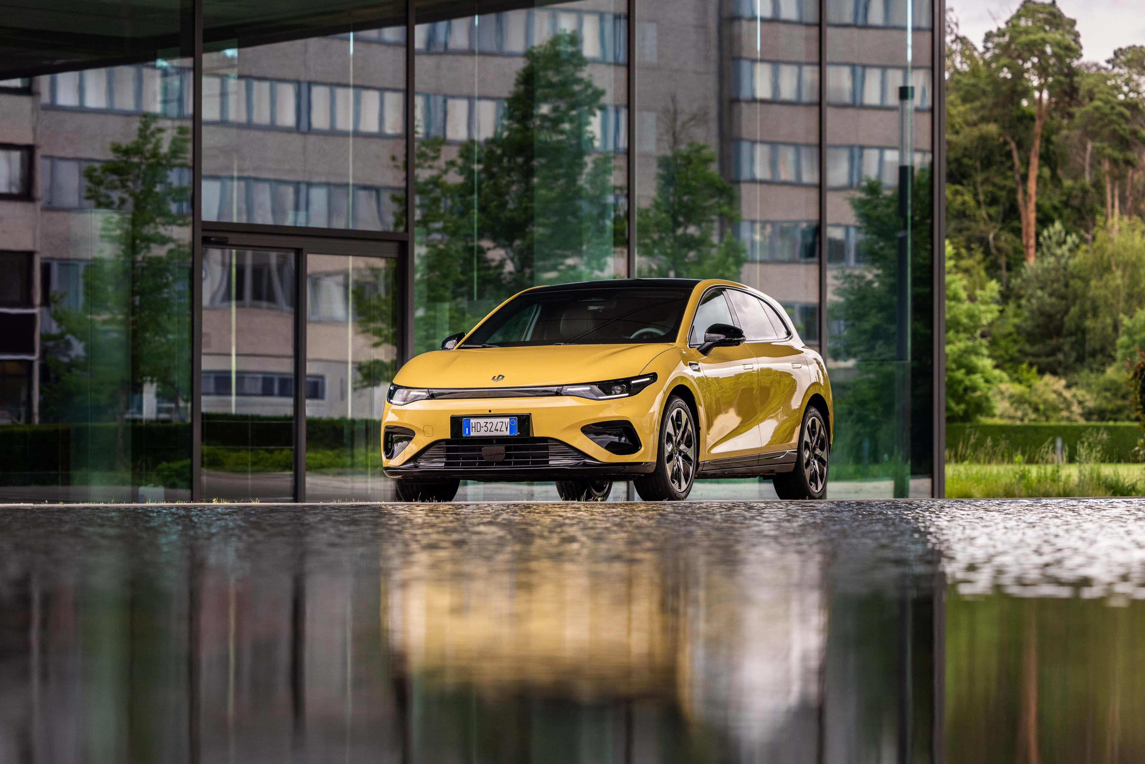 A yellow Leapmotor B05 parked in front of an apartment