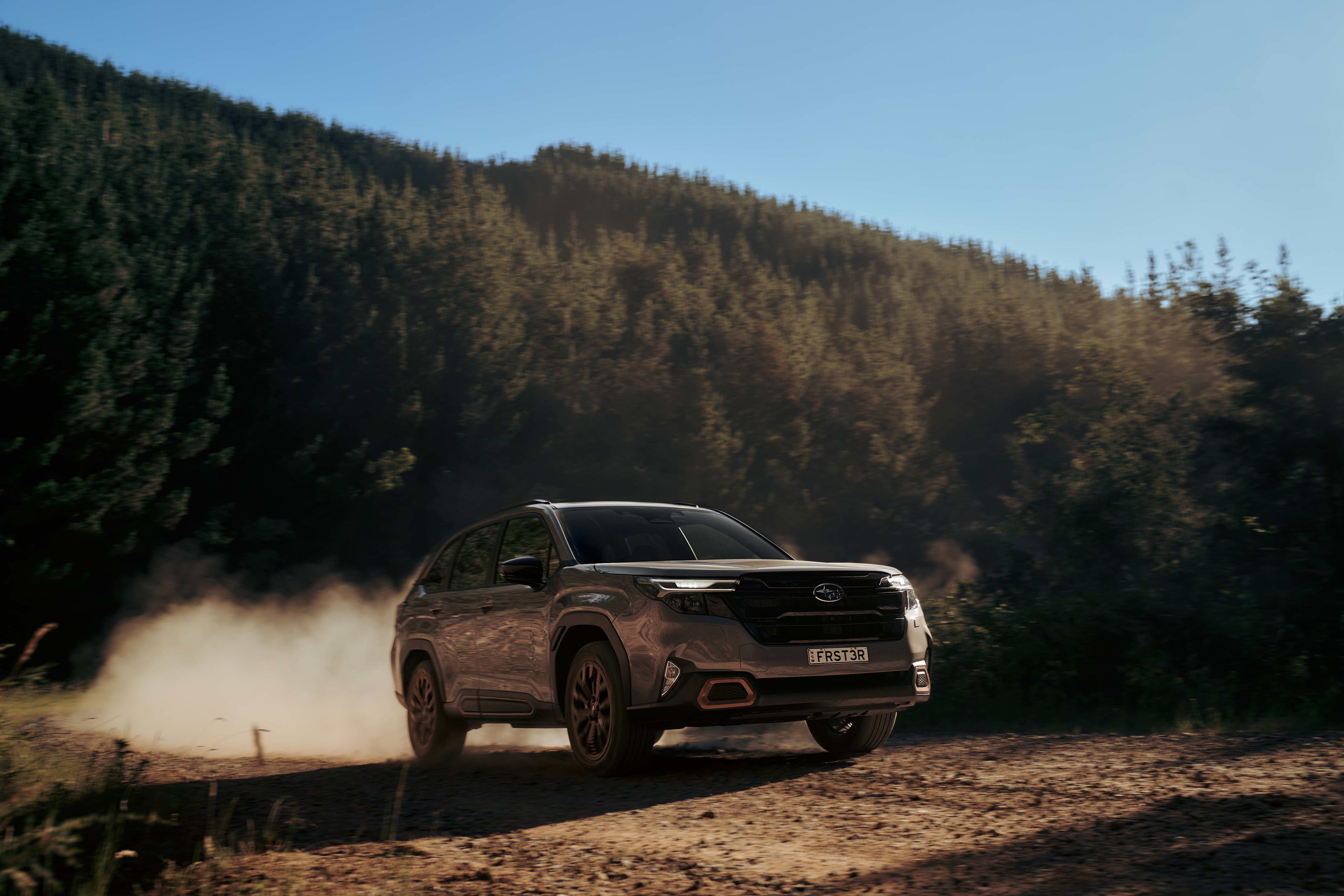 A silver Subaru Forester e-boxer driving on a gravel road
