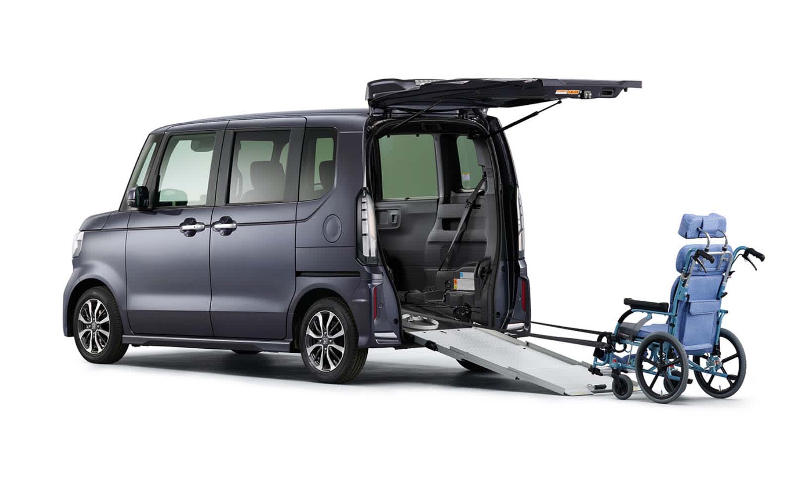 A grey Honda N-Box Custom van with a wheelchair at the rear on a ramp