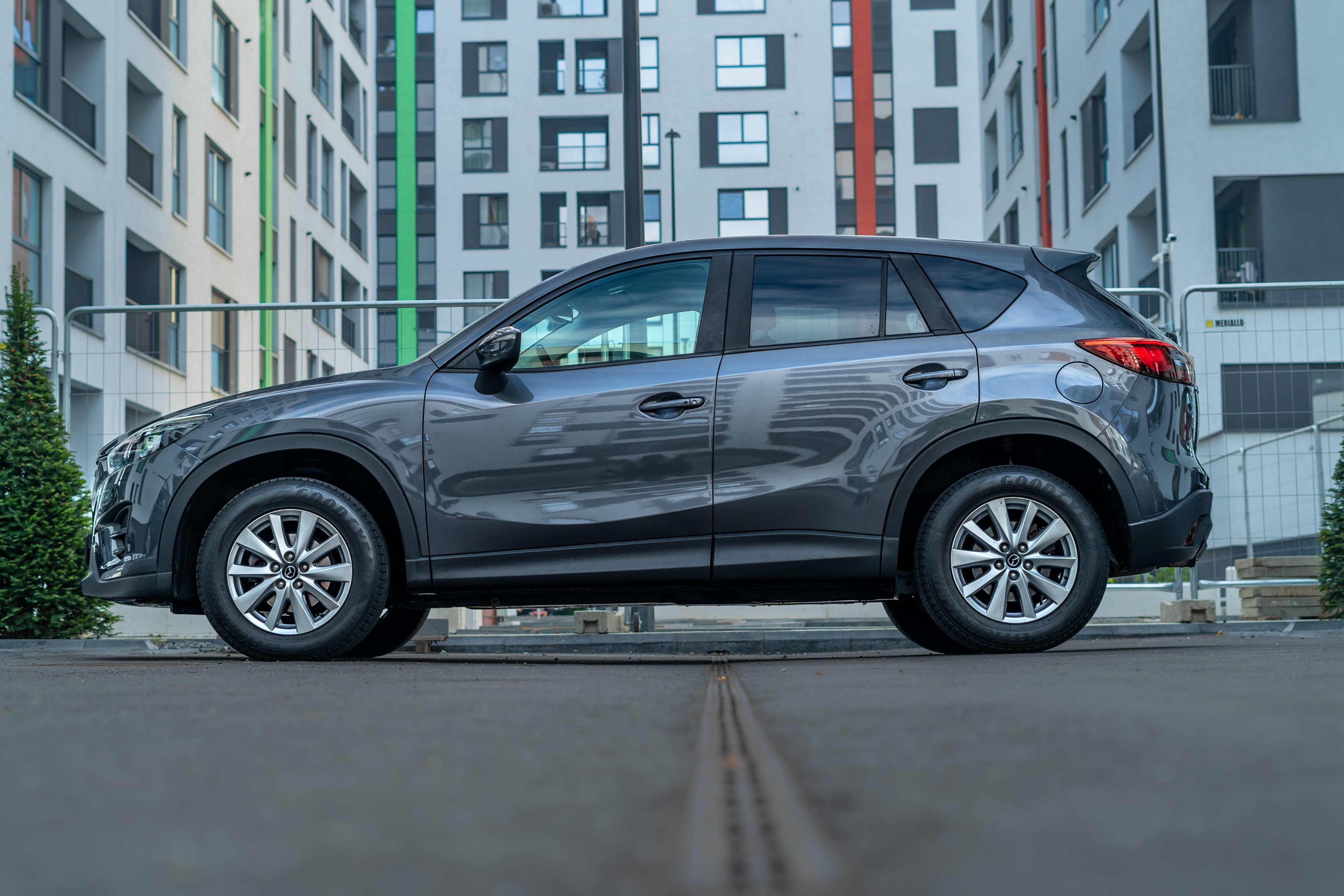 A dark silver four-wheel-drive parked on an inner city street