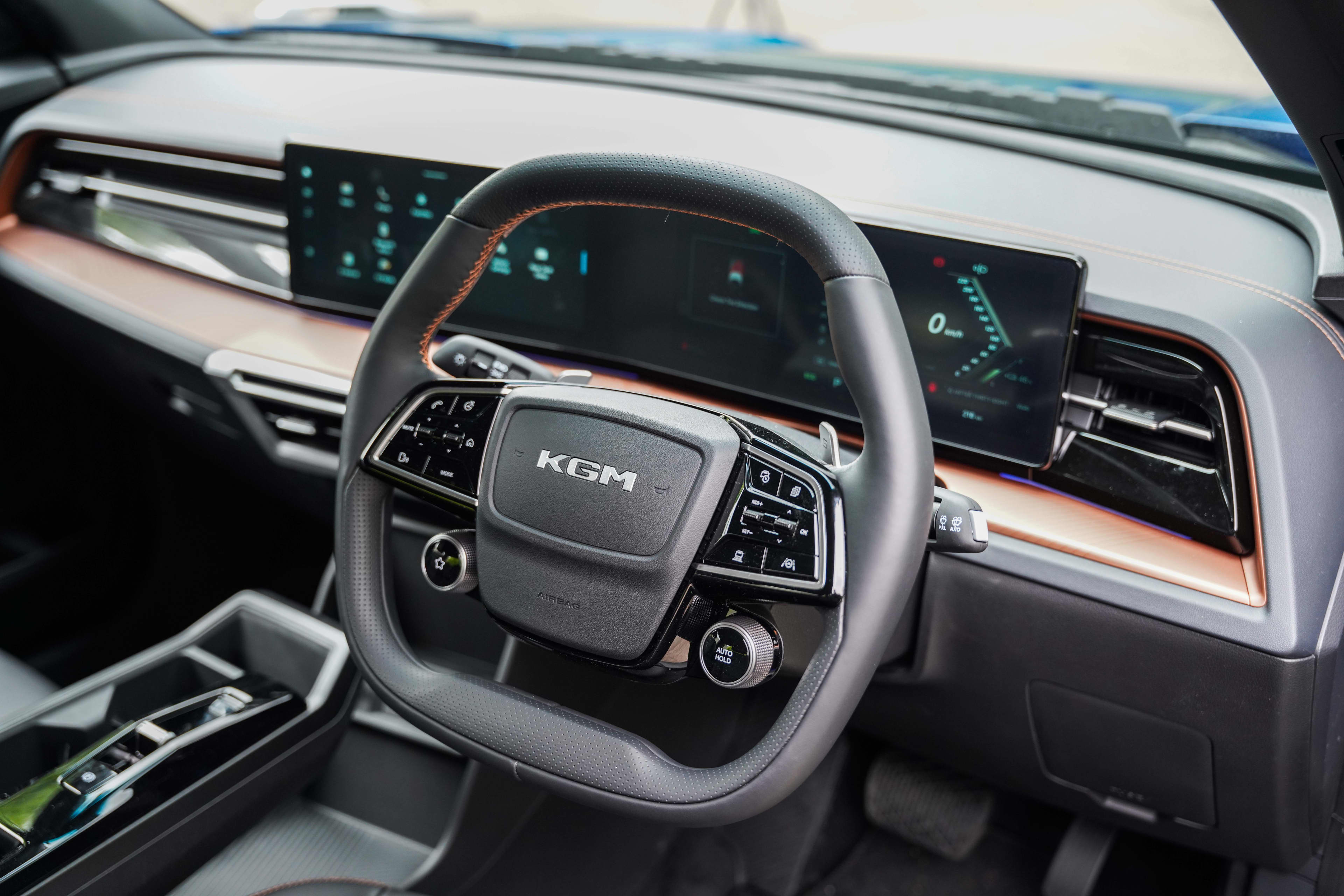 The steering wheel and dashboard of a KGM Musso EV ute.